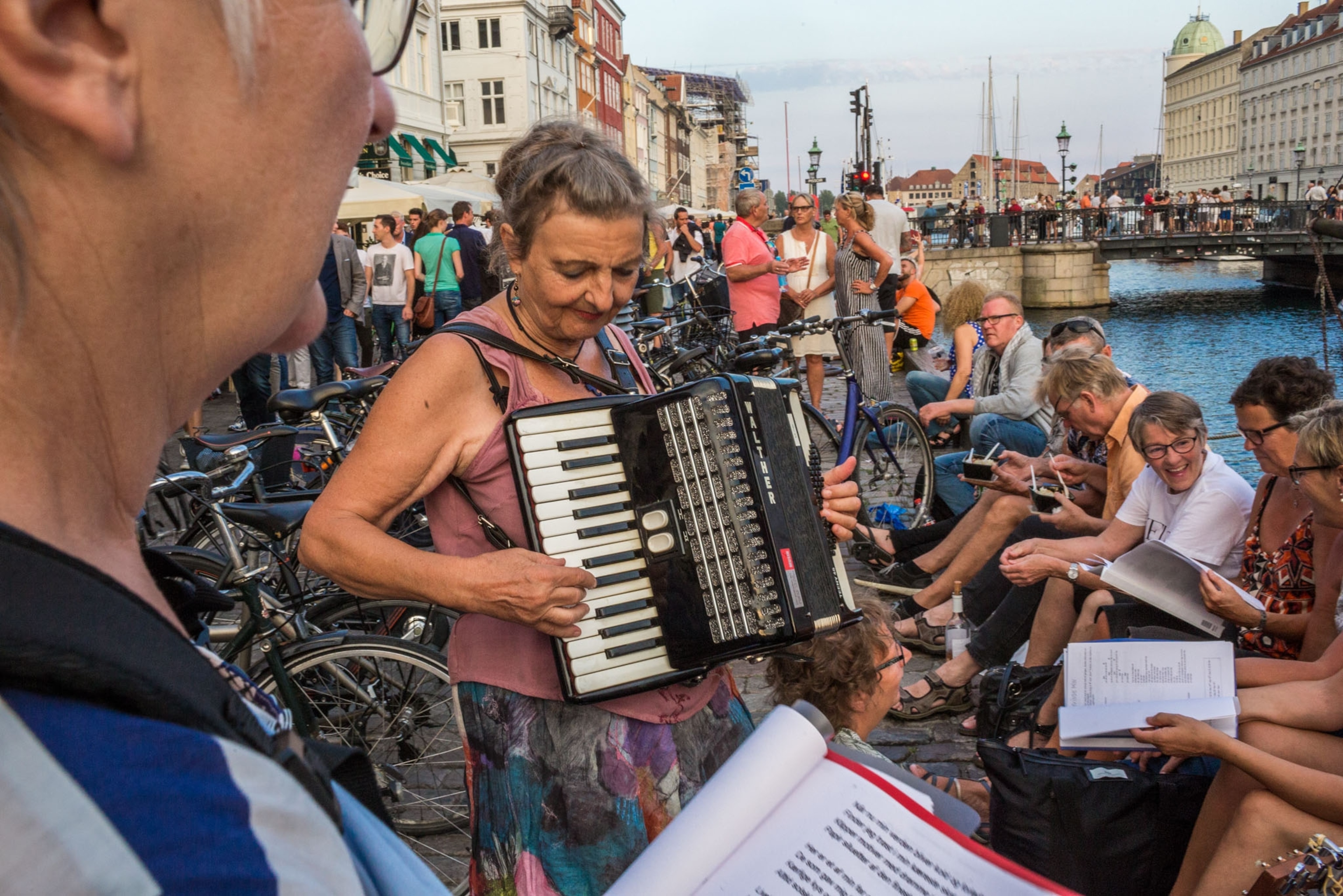 members of a singles club socializing, singing, and drinking on Nyhavn, Copenhagen.