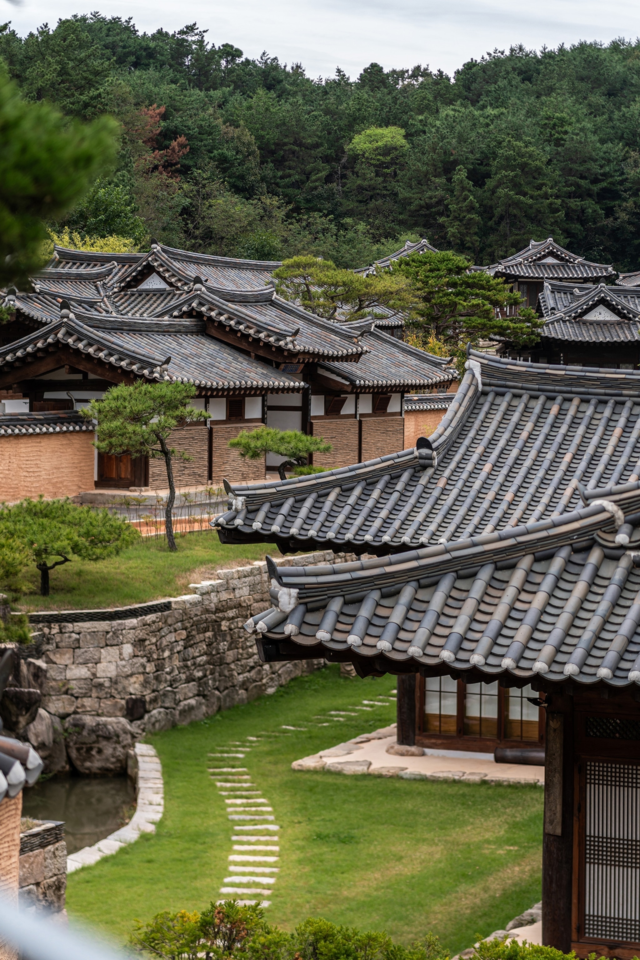The tiled rooftops of Rakkojae Hahoe Hanok Hotel blend harmoniously with the surrounding mountains, preserving the elegance of Korea’s hanok architecture.
