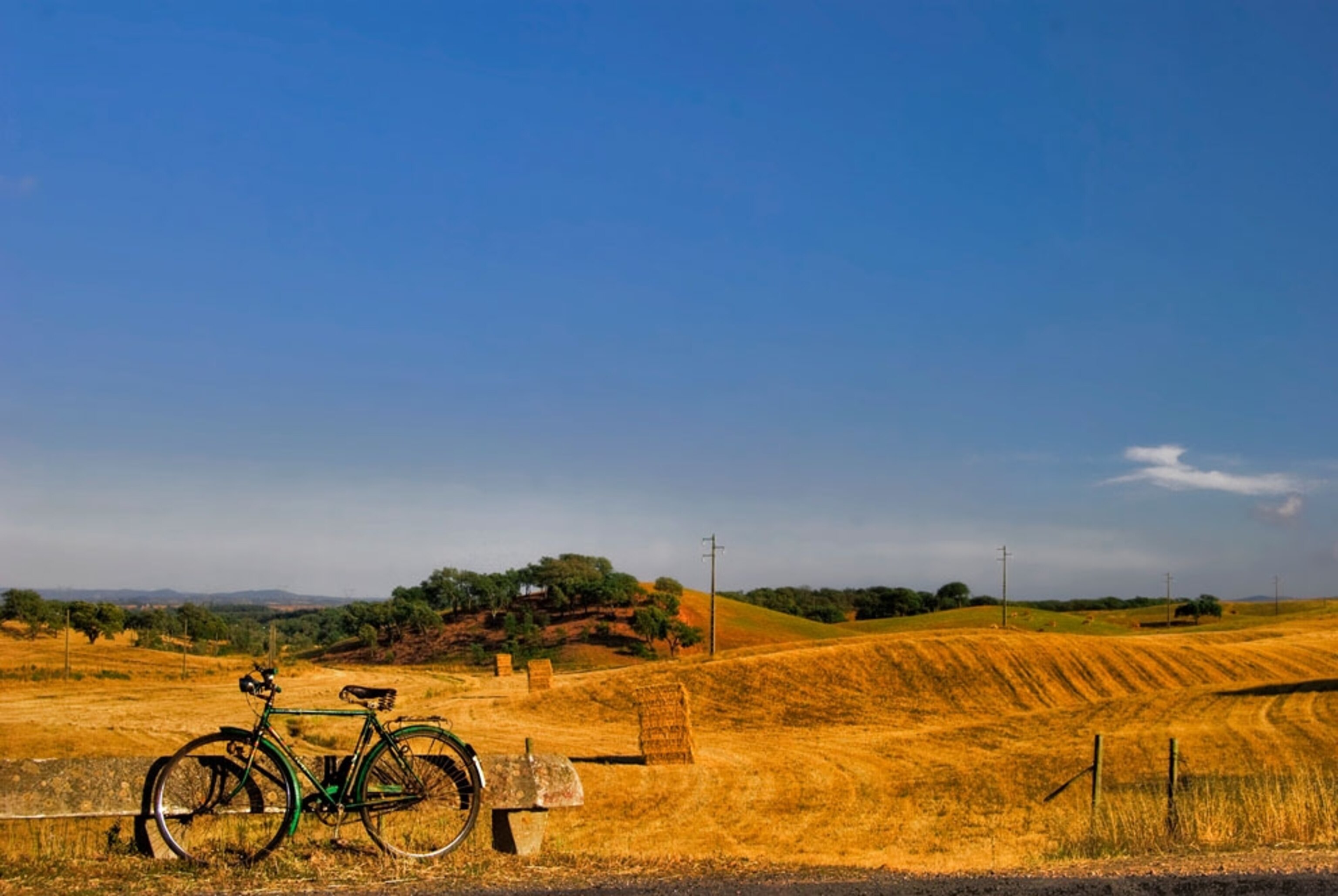 A bike resting on a fence near fields in Alentejo, Portugal