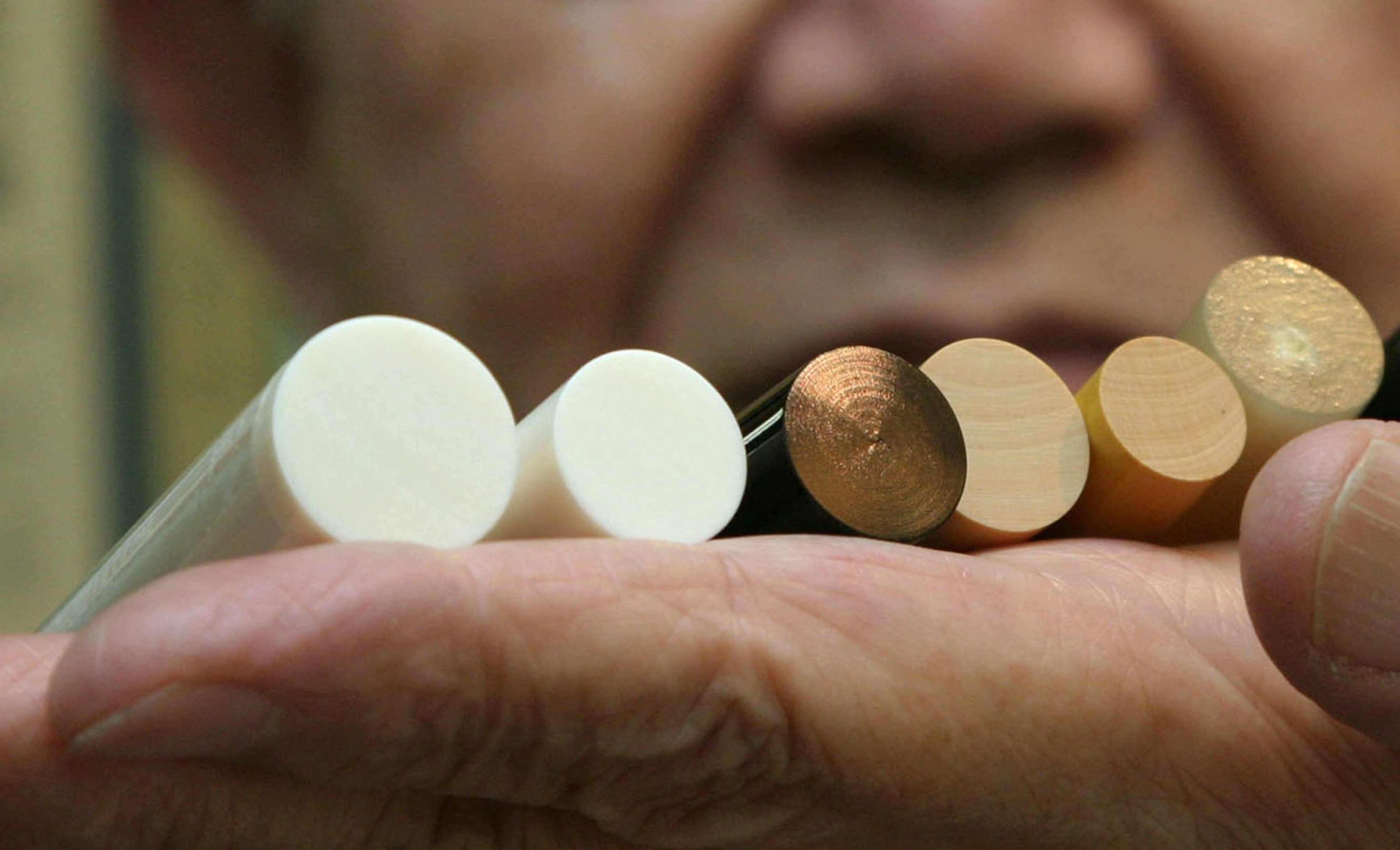 man holding Japanese personal seals made of various materials