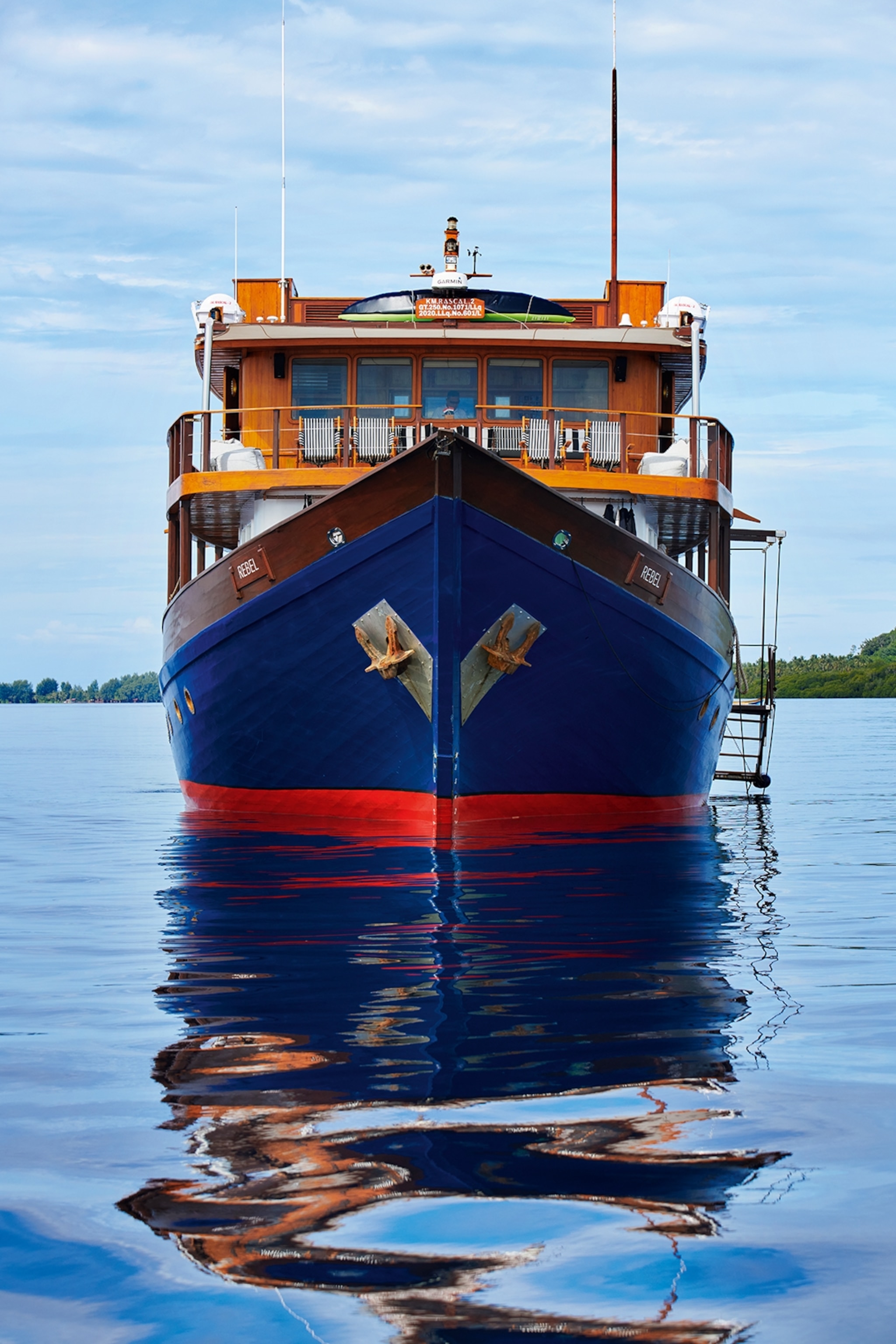 A shot of a low-rise river boat from the front in the ocean.