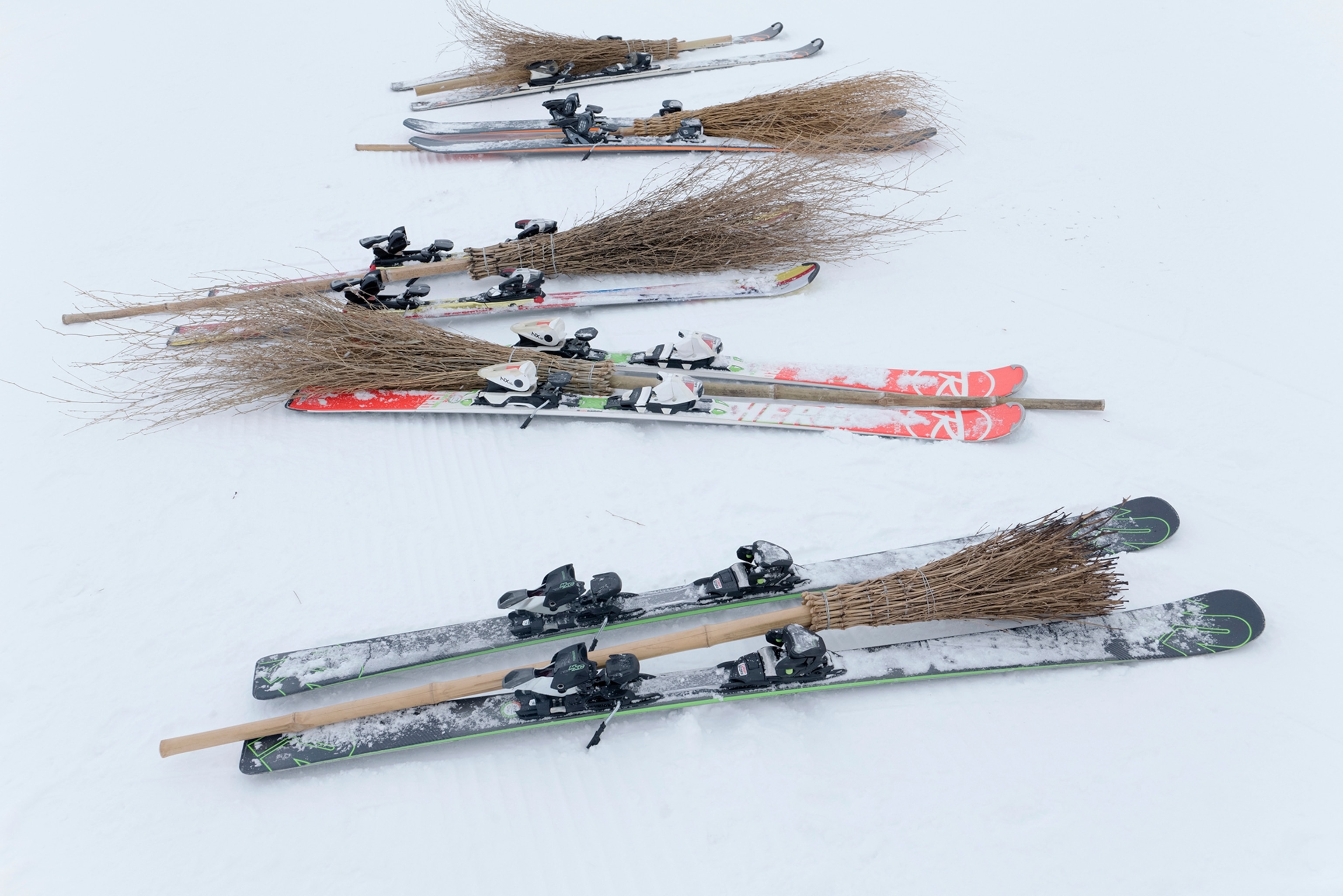 Broomsticks and skis rest on the snow during the Belalp Hexen festival in Belalp, Switzerland. The festival includes races and witch themed activities.