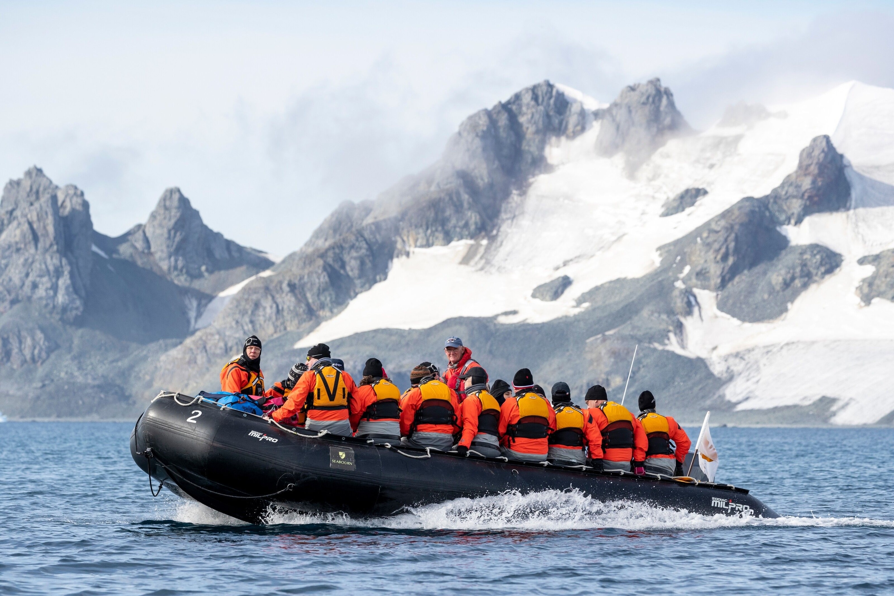 A group head out in a tender. A large glacier can be seen in the background.