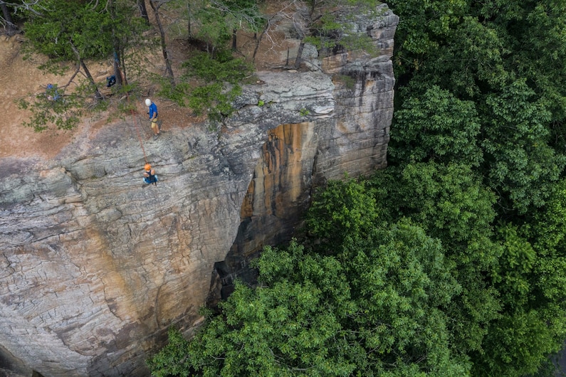 two people climbing up the Bridge Buttress rock formation