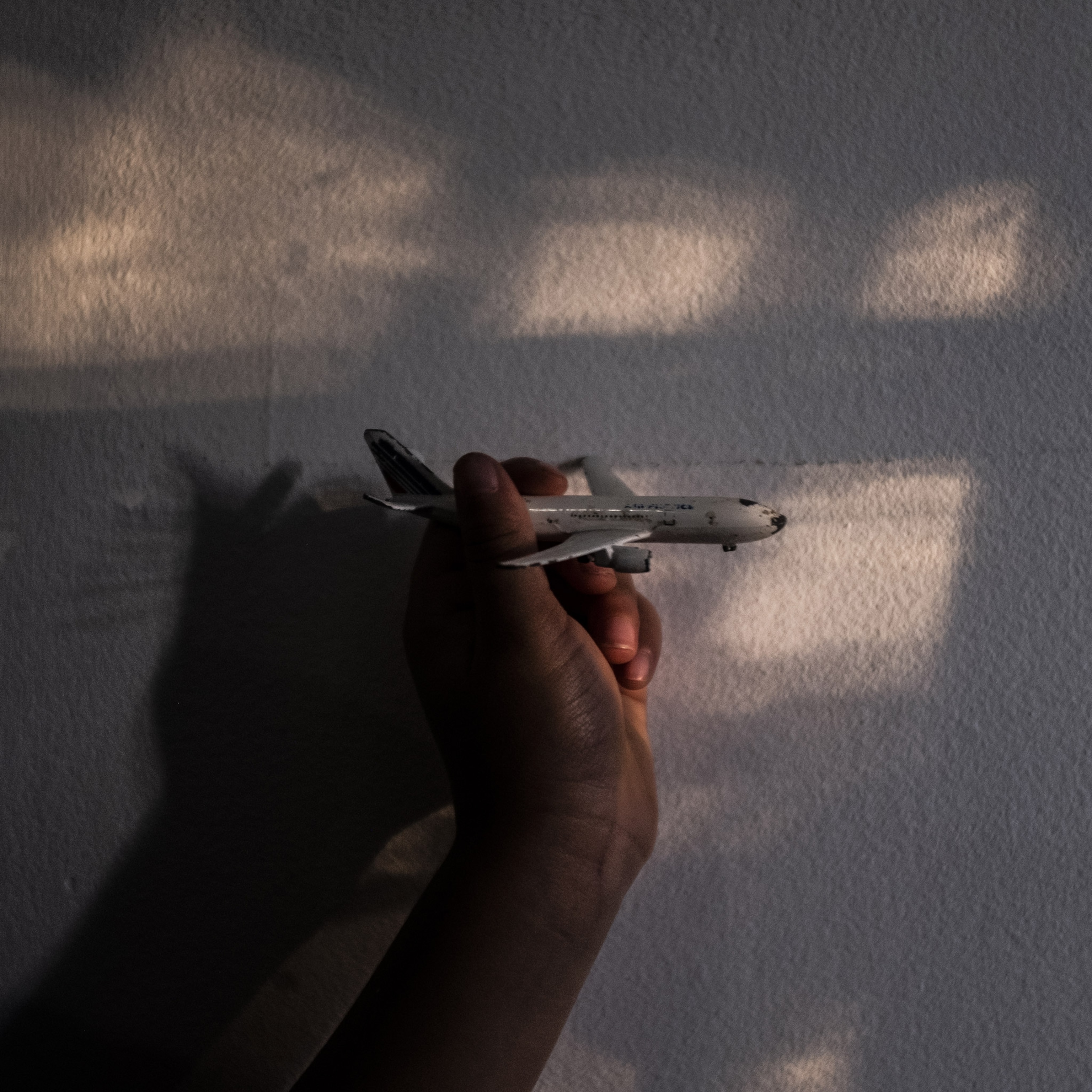 a hand holding a toy airplane