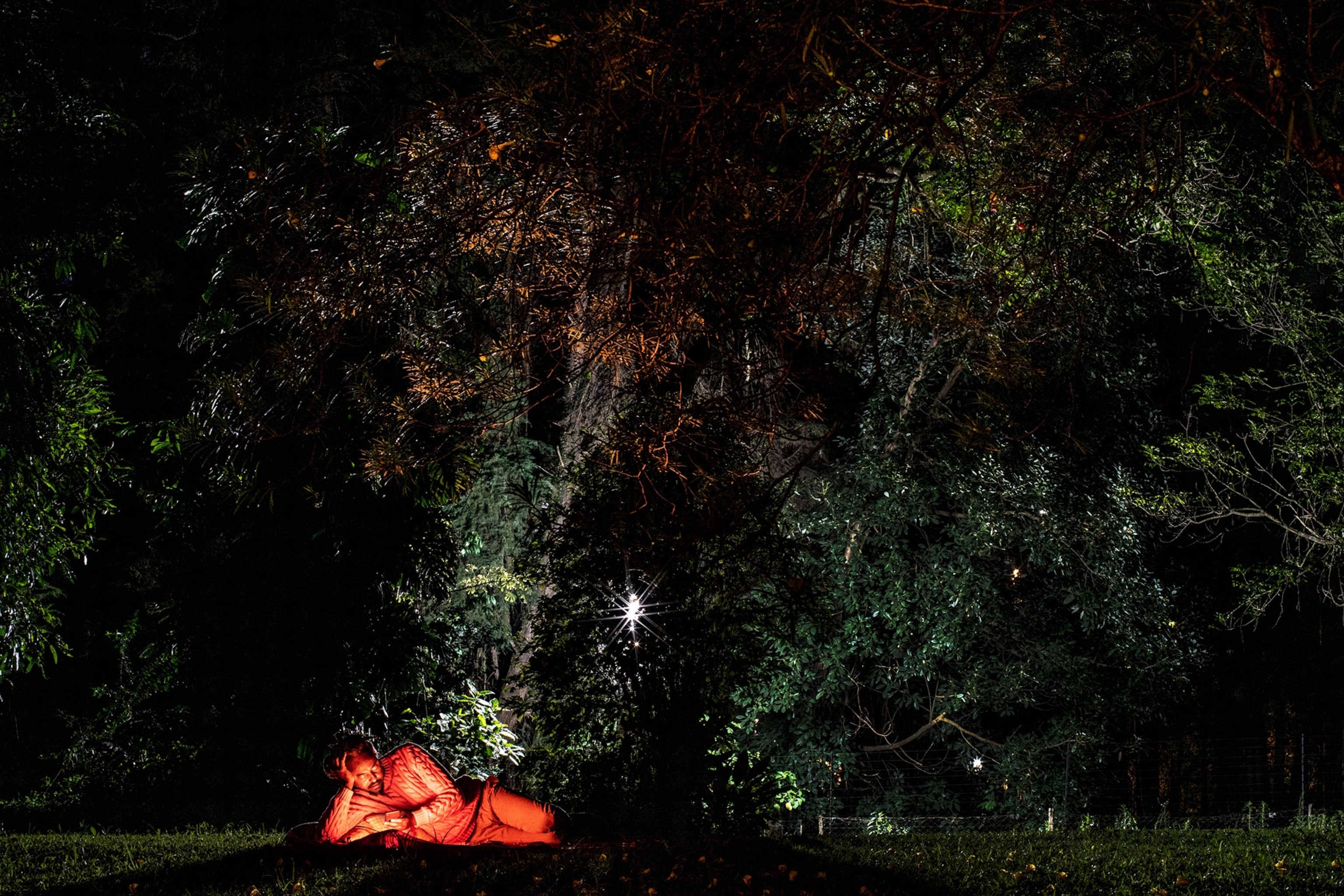 a man laying under a tree at night in Nairobi, Kenya