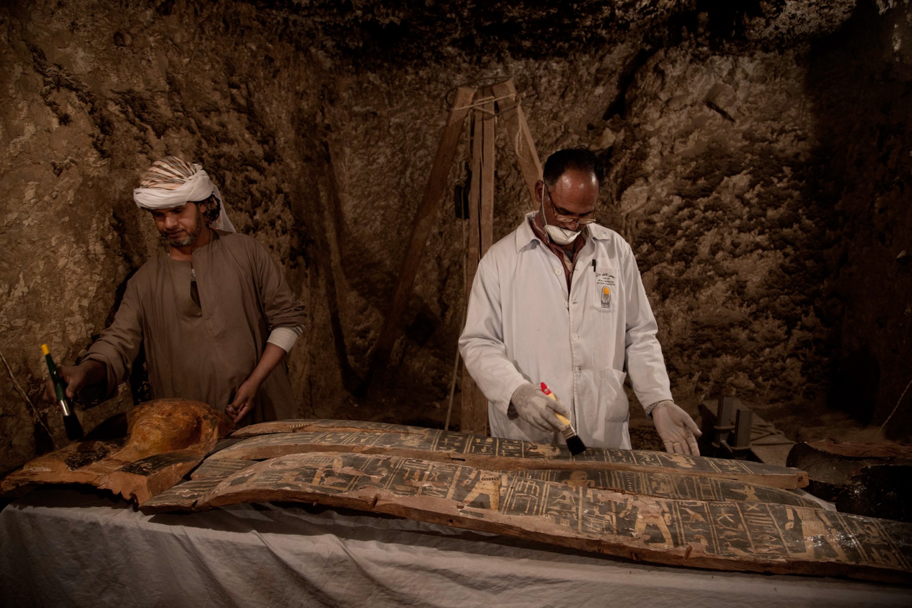 Egyptian excavation workers restoring an unidentified funerary coffin