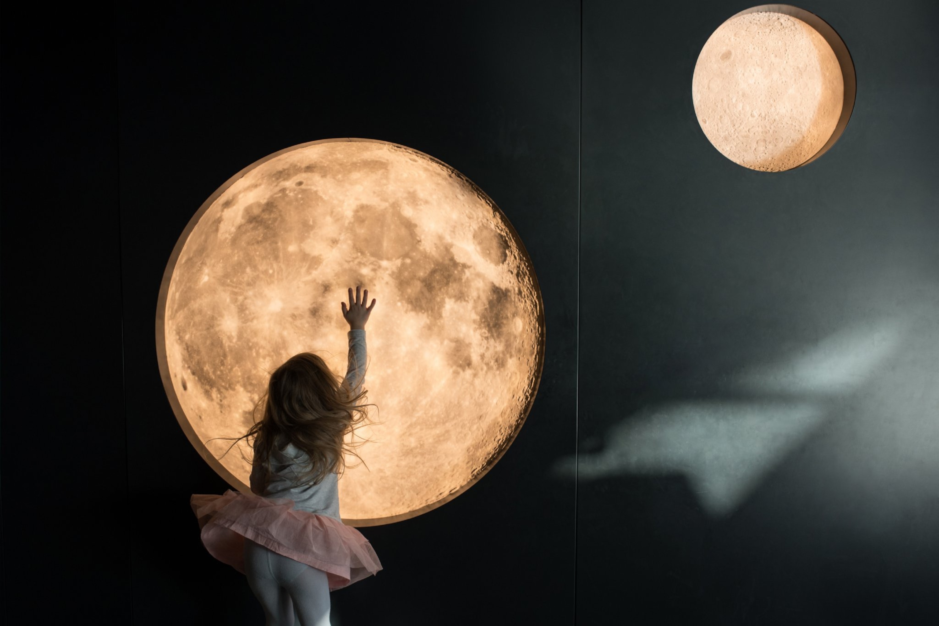 a young girl touching a moon diagram.