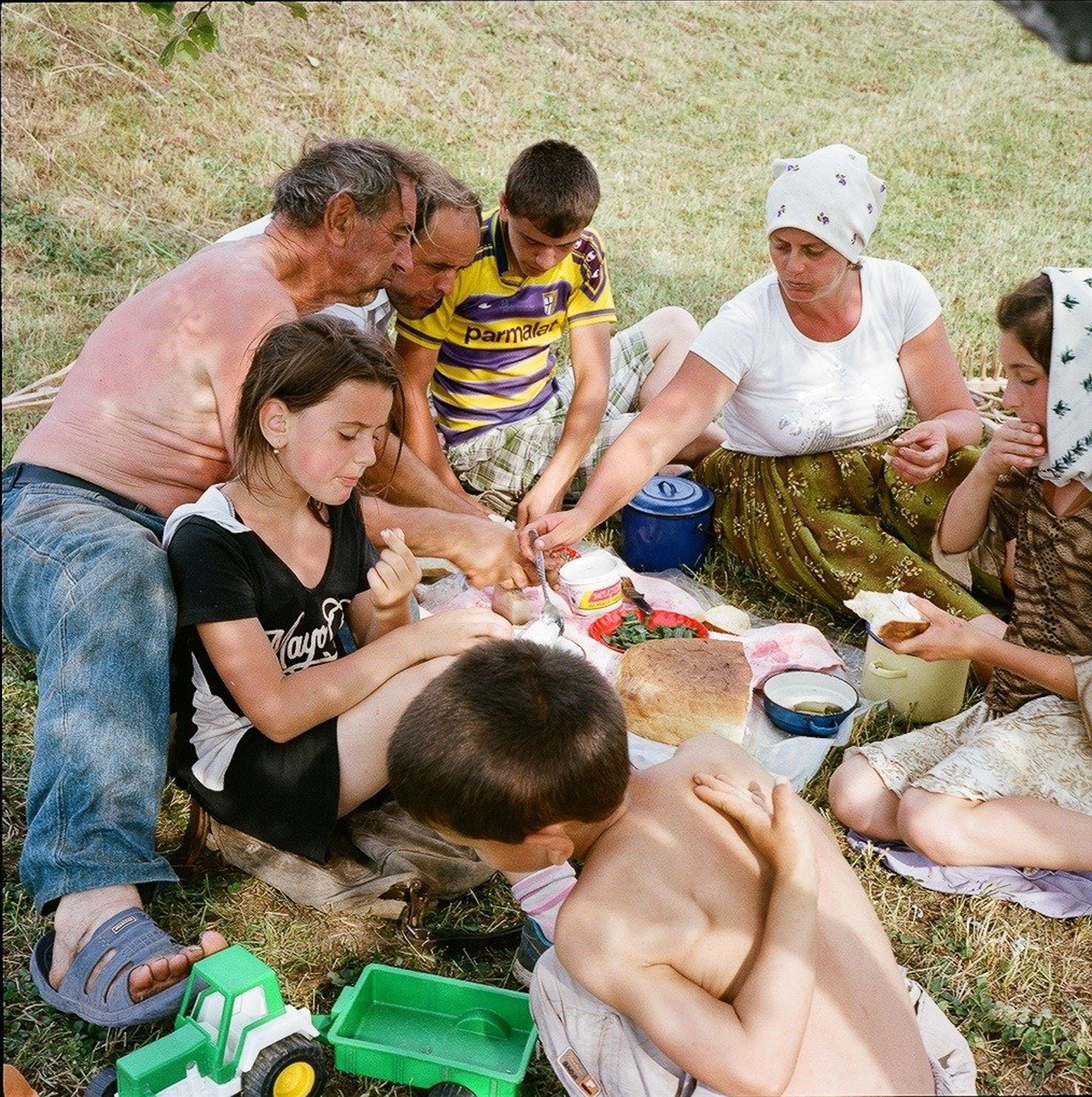 a family taking a break from haymaking to share a meal in Breb village, Maramures, Romania in 2012.