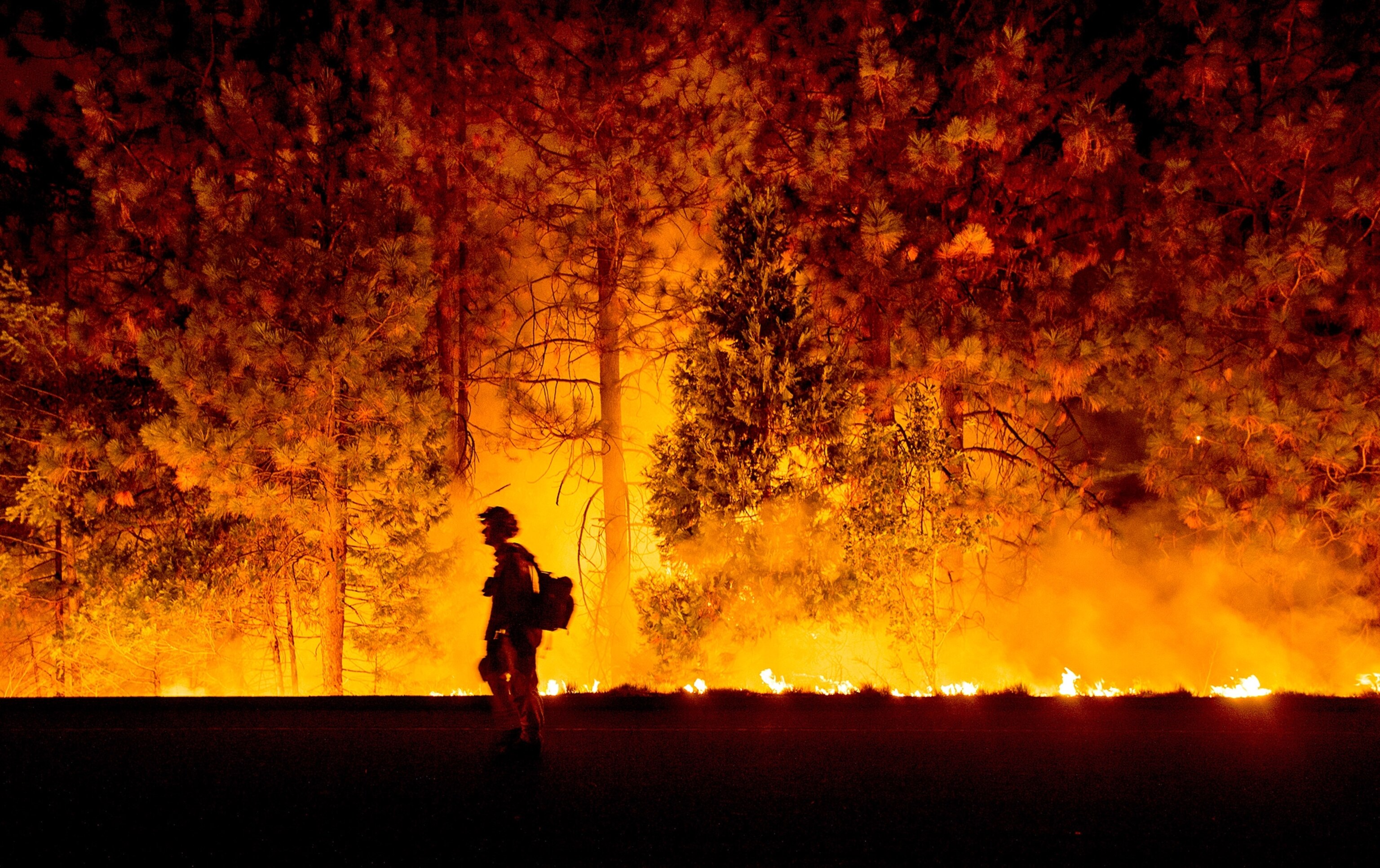 a firefighter battling the King Fire along Highway 50 in Fresh Pond, California.