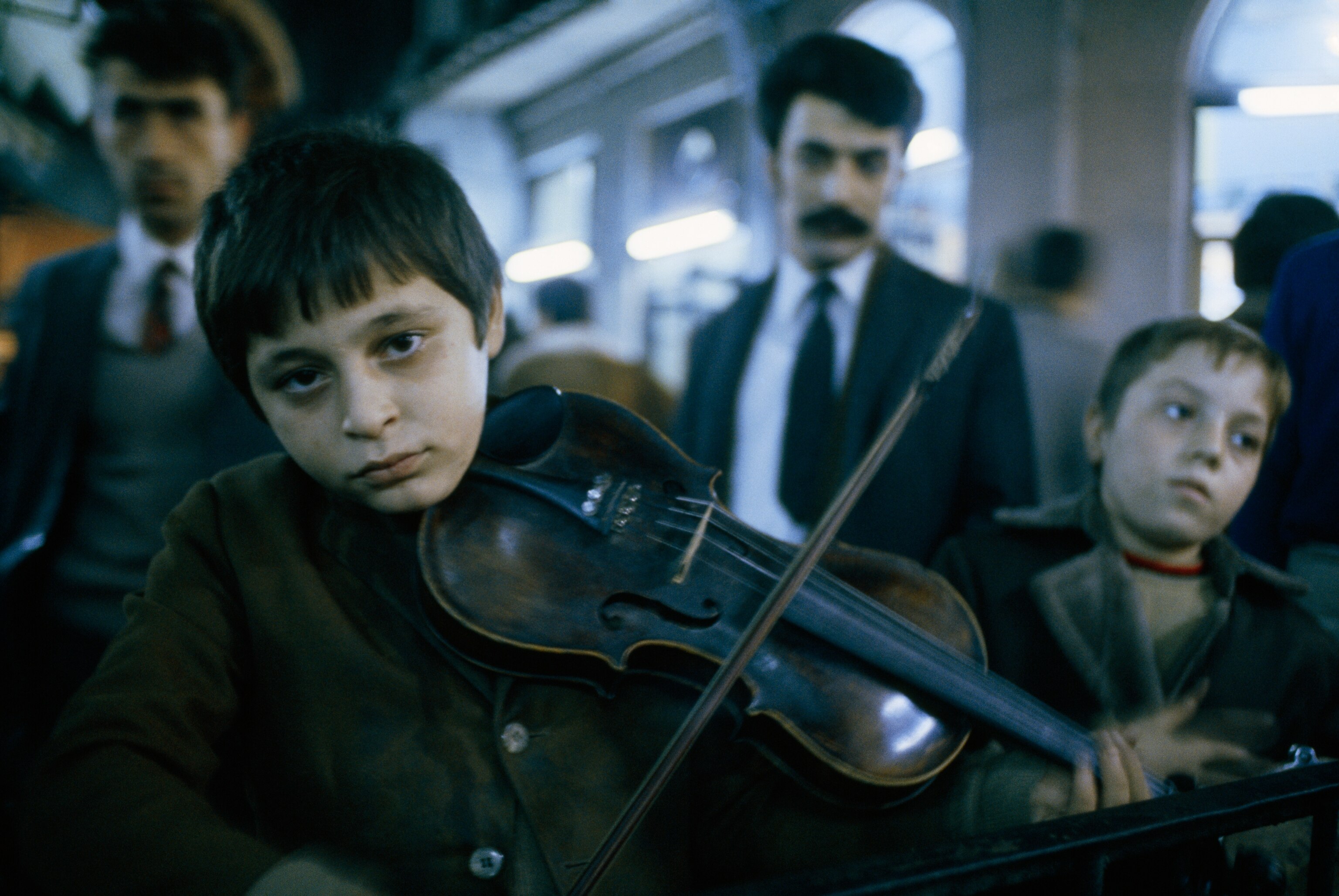 A young boy playing the violin with another boy playing the tambourine in Istanbul