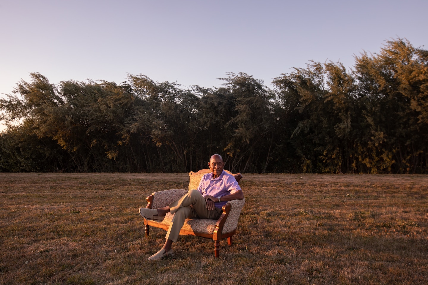 A man on a couch in a field