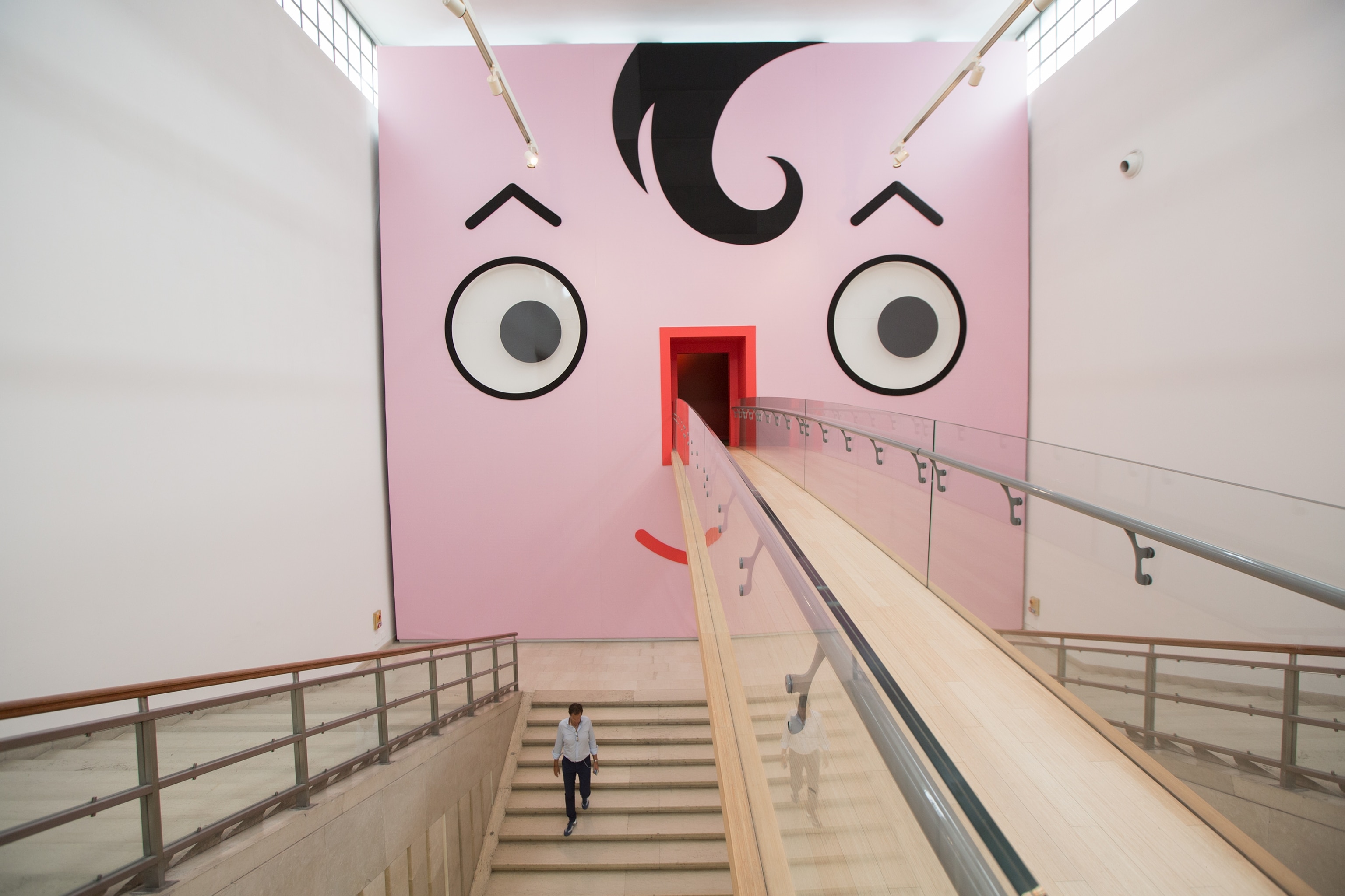 a visitor on the entrance stairway of the Triennale Museum in Milan, Italy