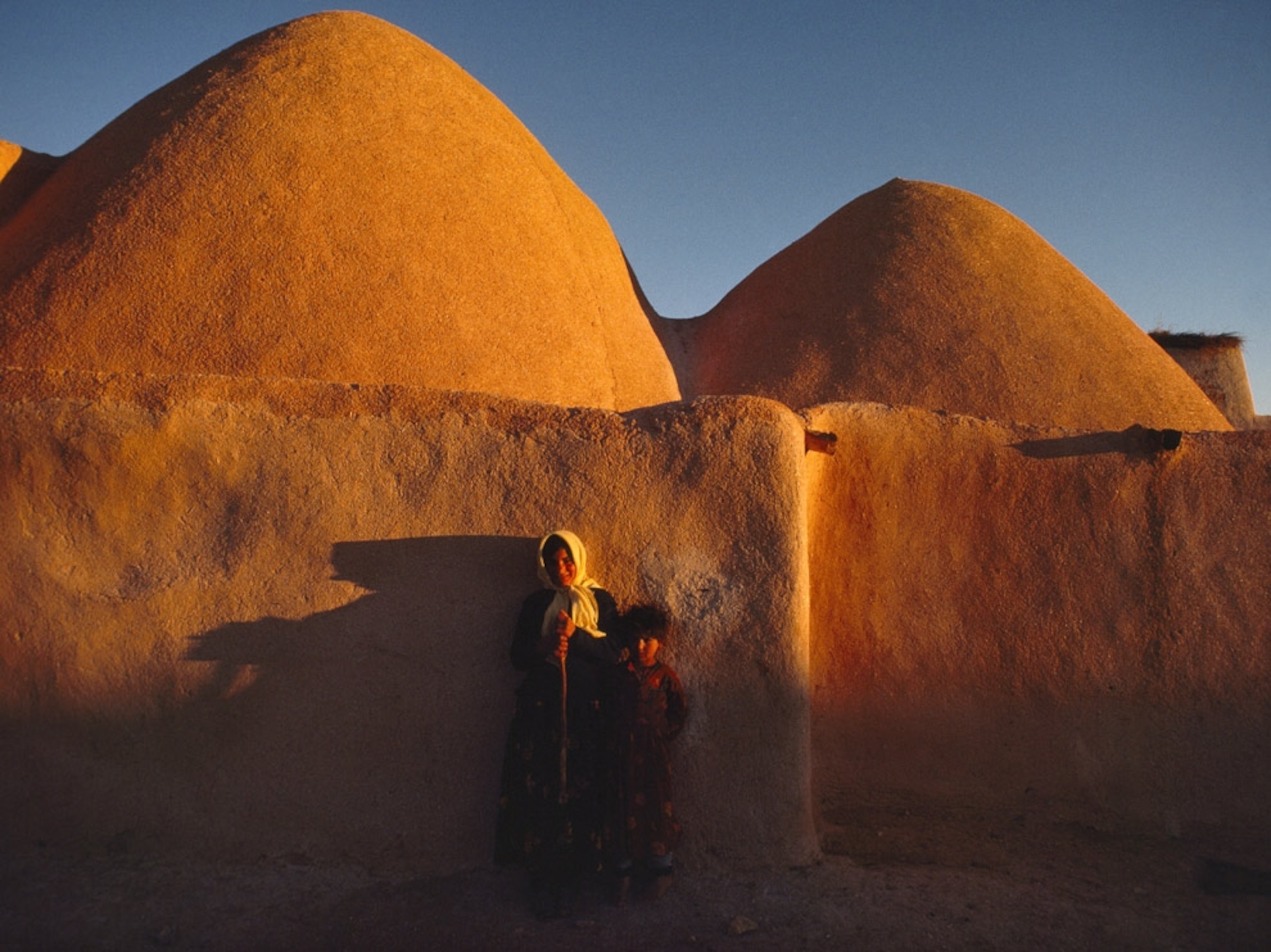 Woman and child near domed huts