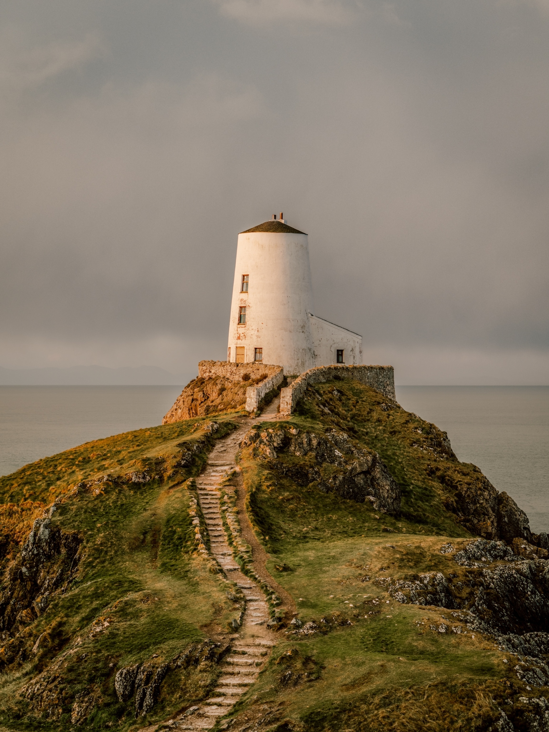 A path leading towards a lighthouse off the coast of Anglesey.