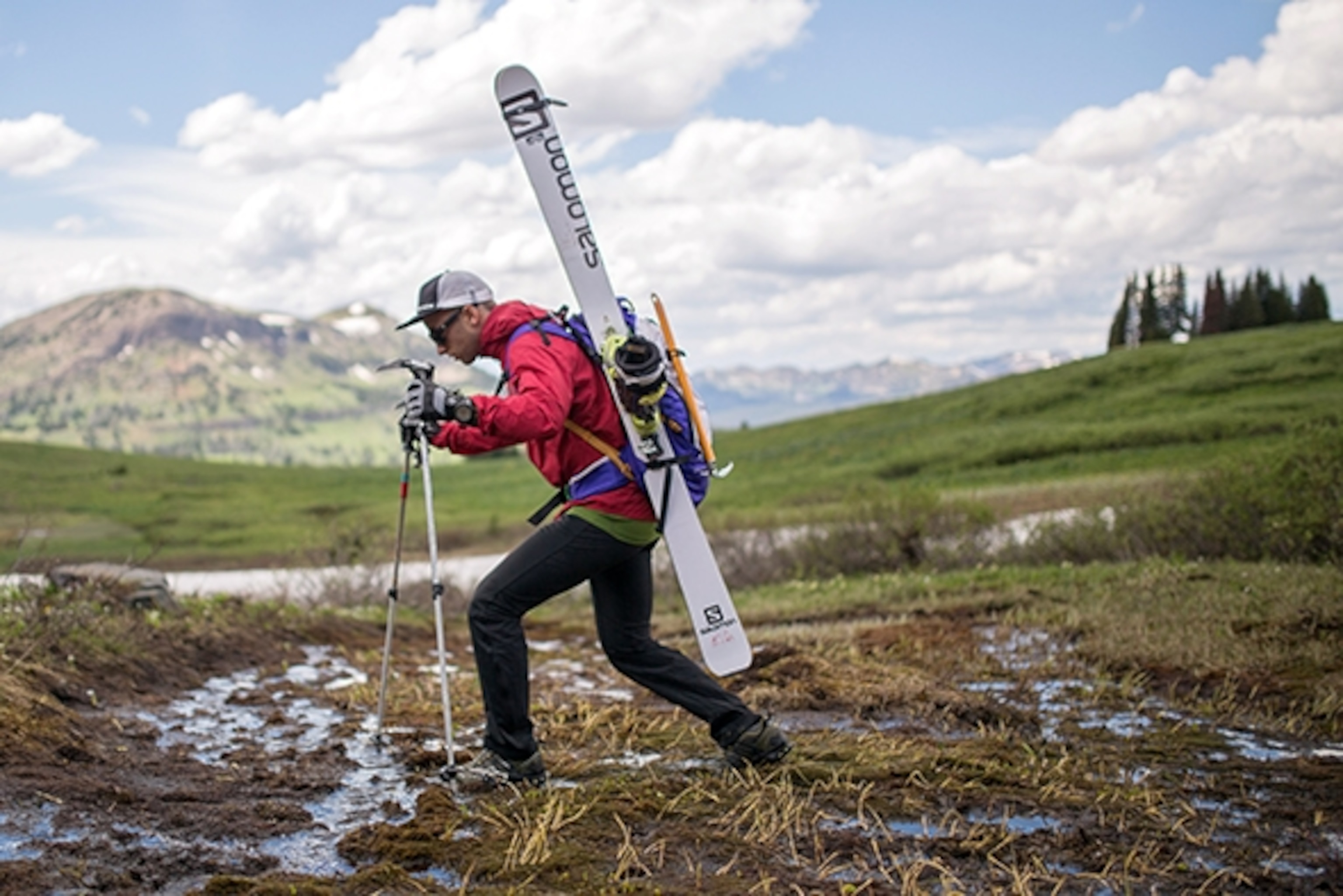 Brody Leven steps through a bog en route to the base of a ski. ; Photograph by Graeme MacPherson