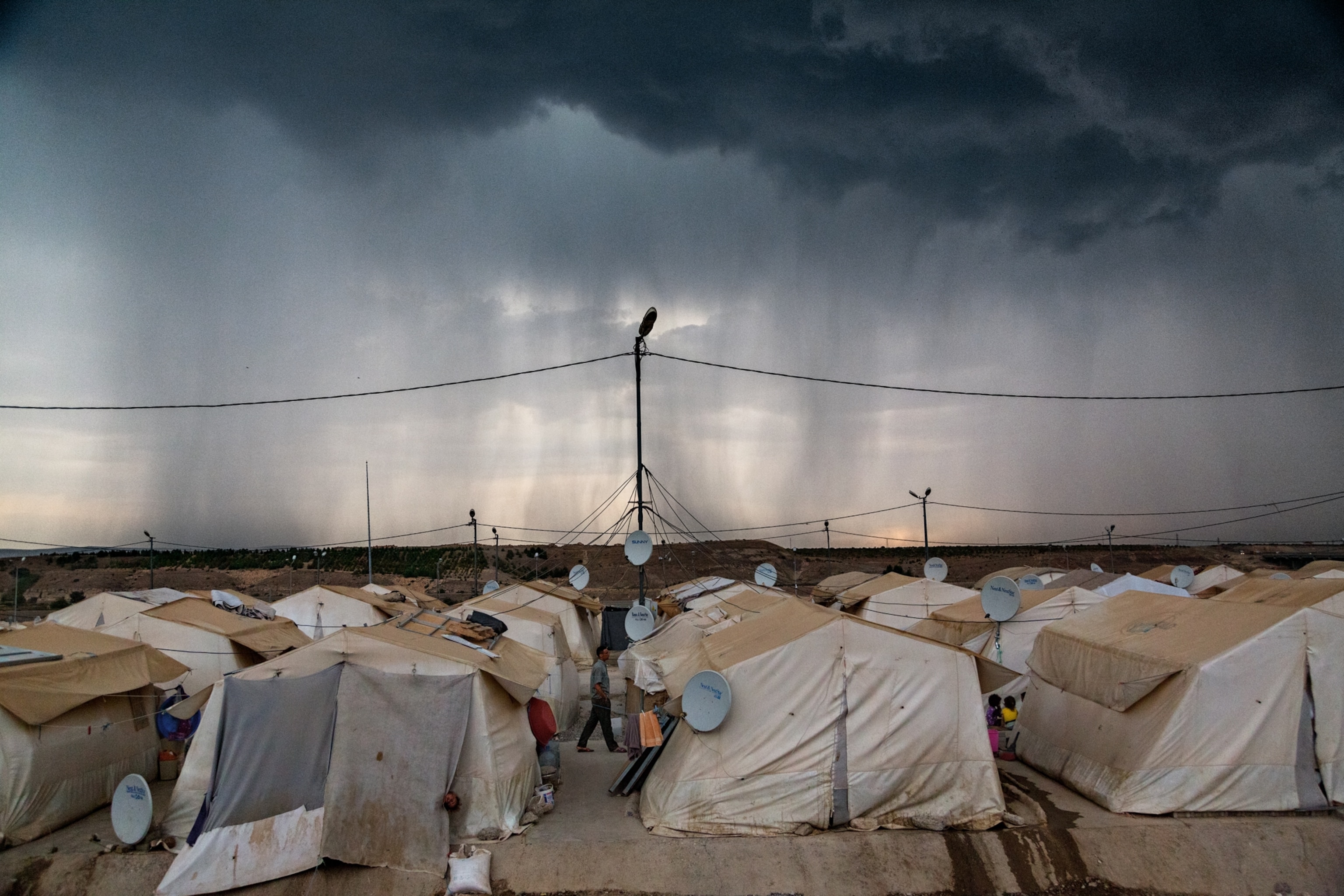 a storm looming over a refugee camp