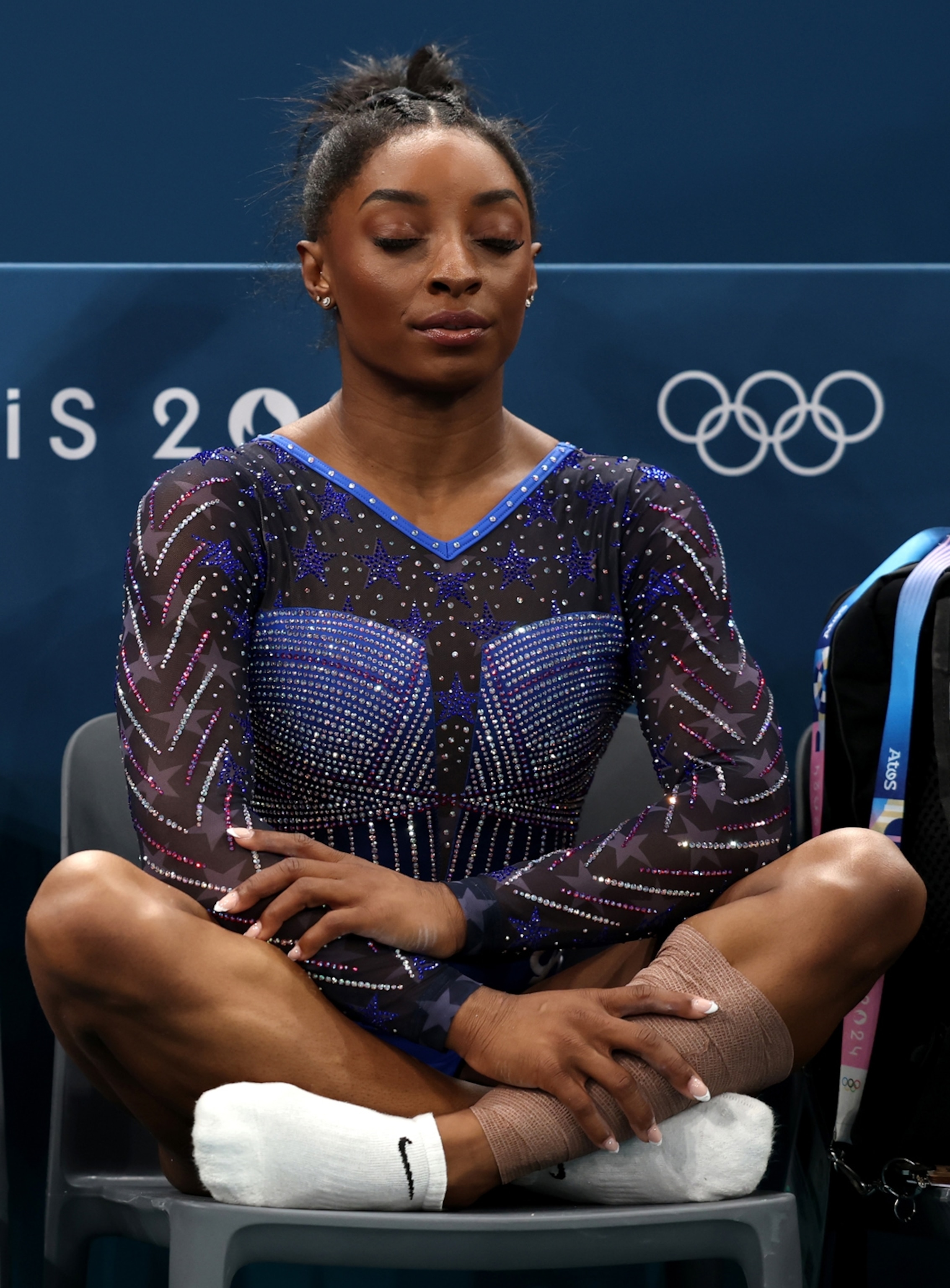 A woman sits on a chair in a meditative position