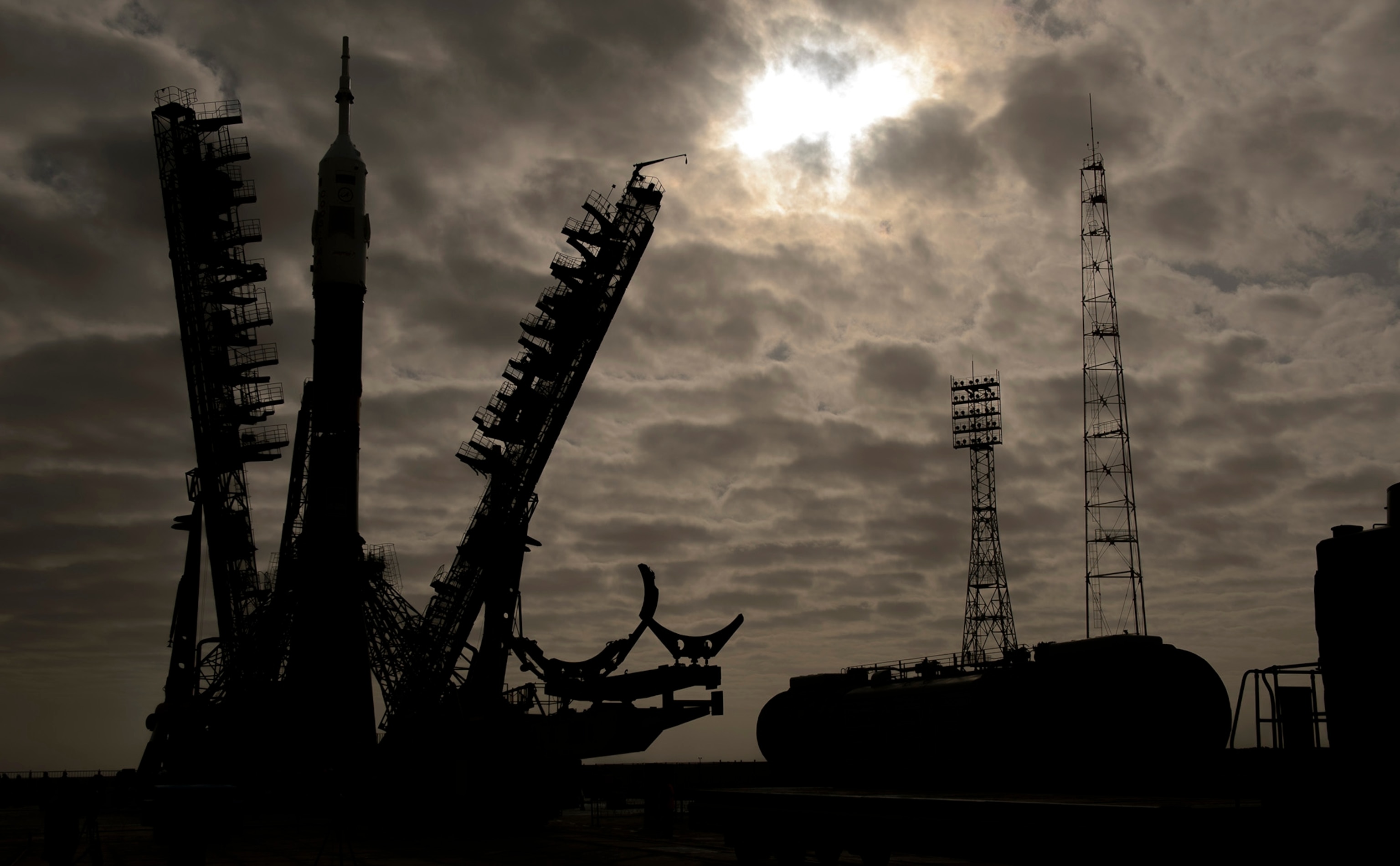 The gantry arms begin to close around the Soyuz TMA-12M spacecraft to secure the rocket at the launch pad on Sunday, March 23, 2014, at the Baikonur Cosmodrome in Kazakhstan. Launch of the Soyuz rocket is scheduled for March 26 and will send Expedition 39 Soyuz Commander Alexander Skvortsov of the Russian Federal Space Agency, Roscosmos, Flight Engineer Steven Swanson of NASA, and Flight Engineer Oleg Artemyev of Roscosmos on a six-month mission aboard the International Space Station. Photo Credit: (NASA/Joel Kowsky)