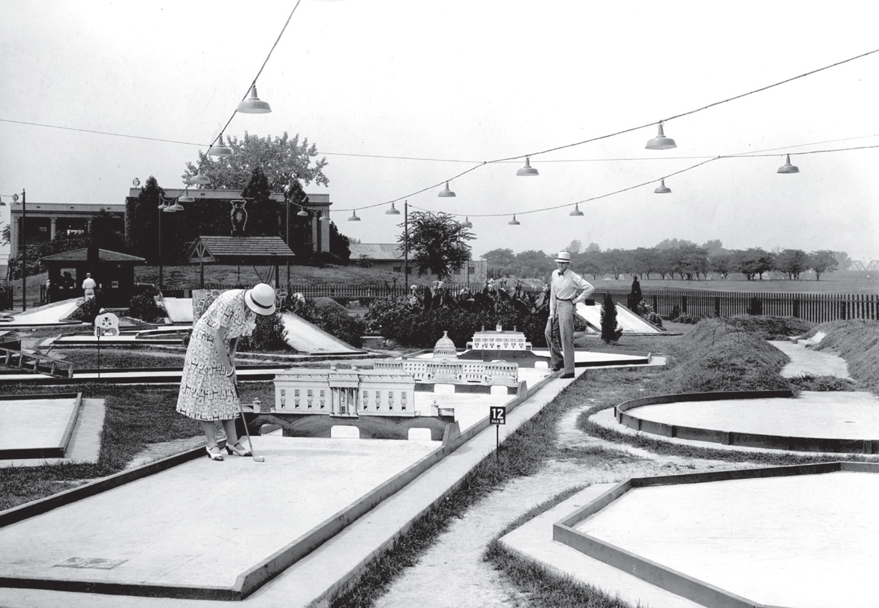 Woman in nice dress and hat playing golf at the course with replicas for Washington DC famous buildings.