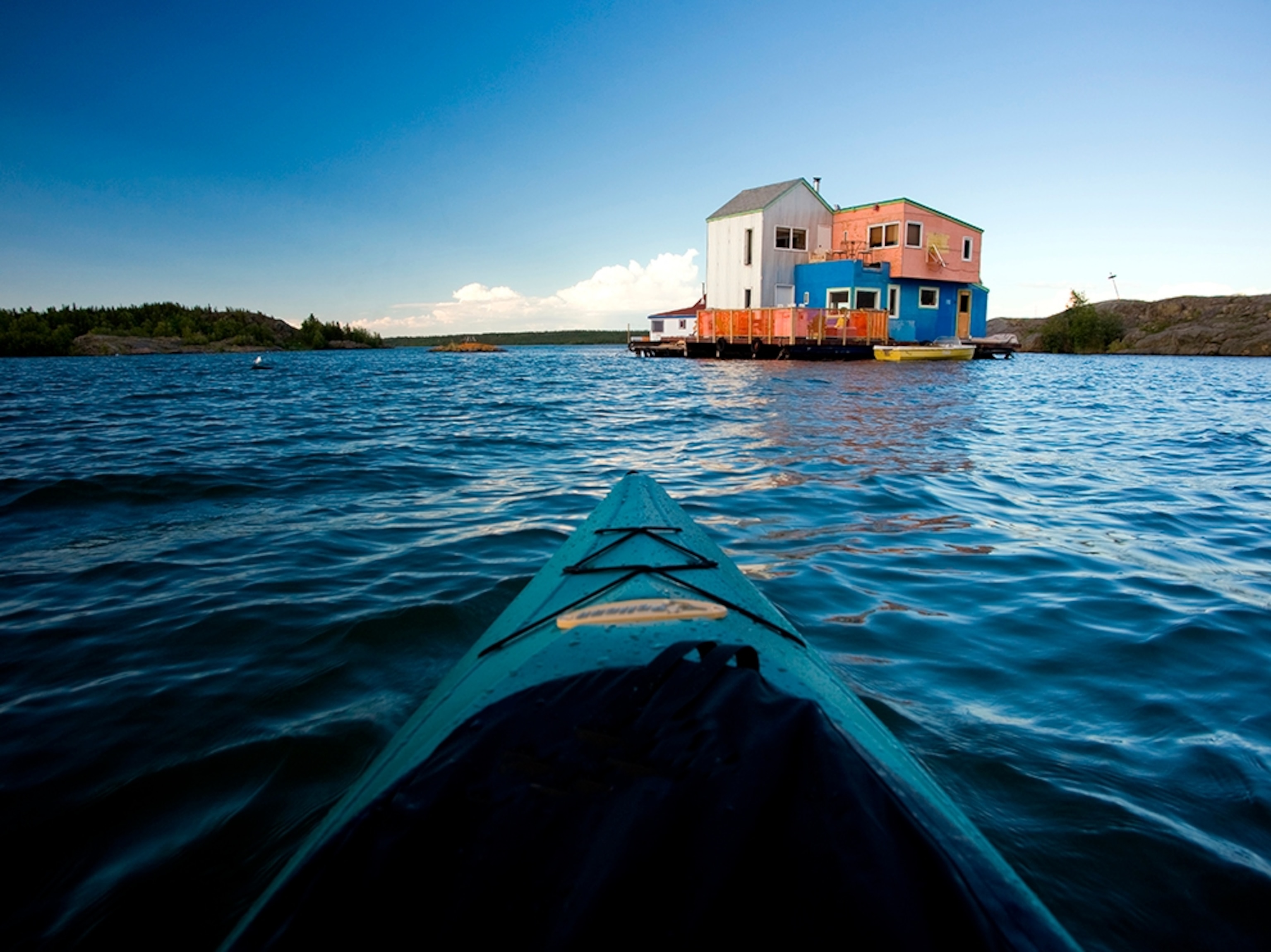 kayaker approaching houseboat, Great Slave Lake, Northwest Territories