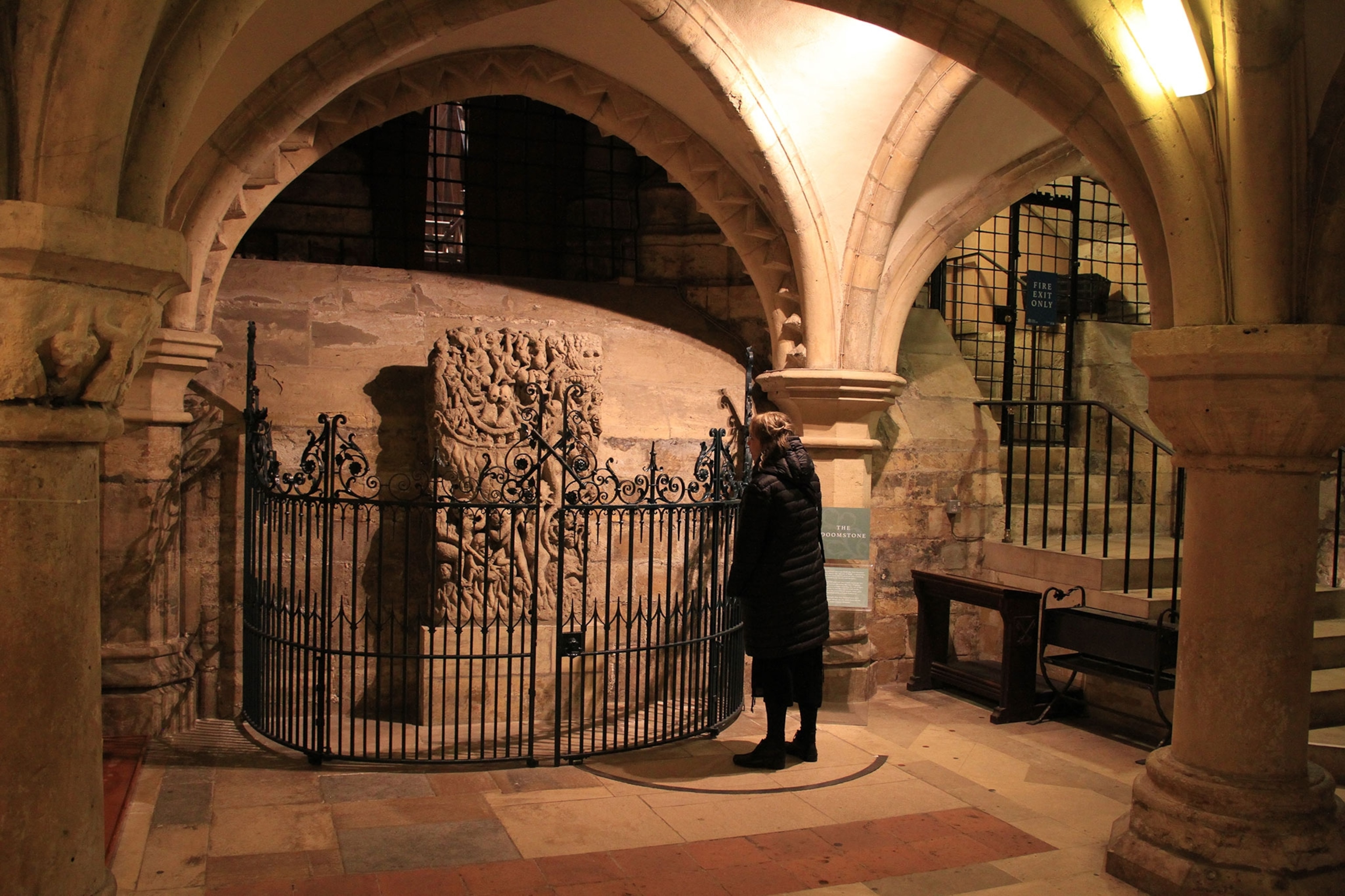 A person dressed in black in front of a tomb.