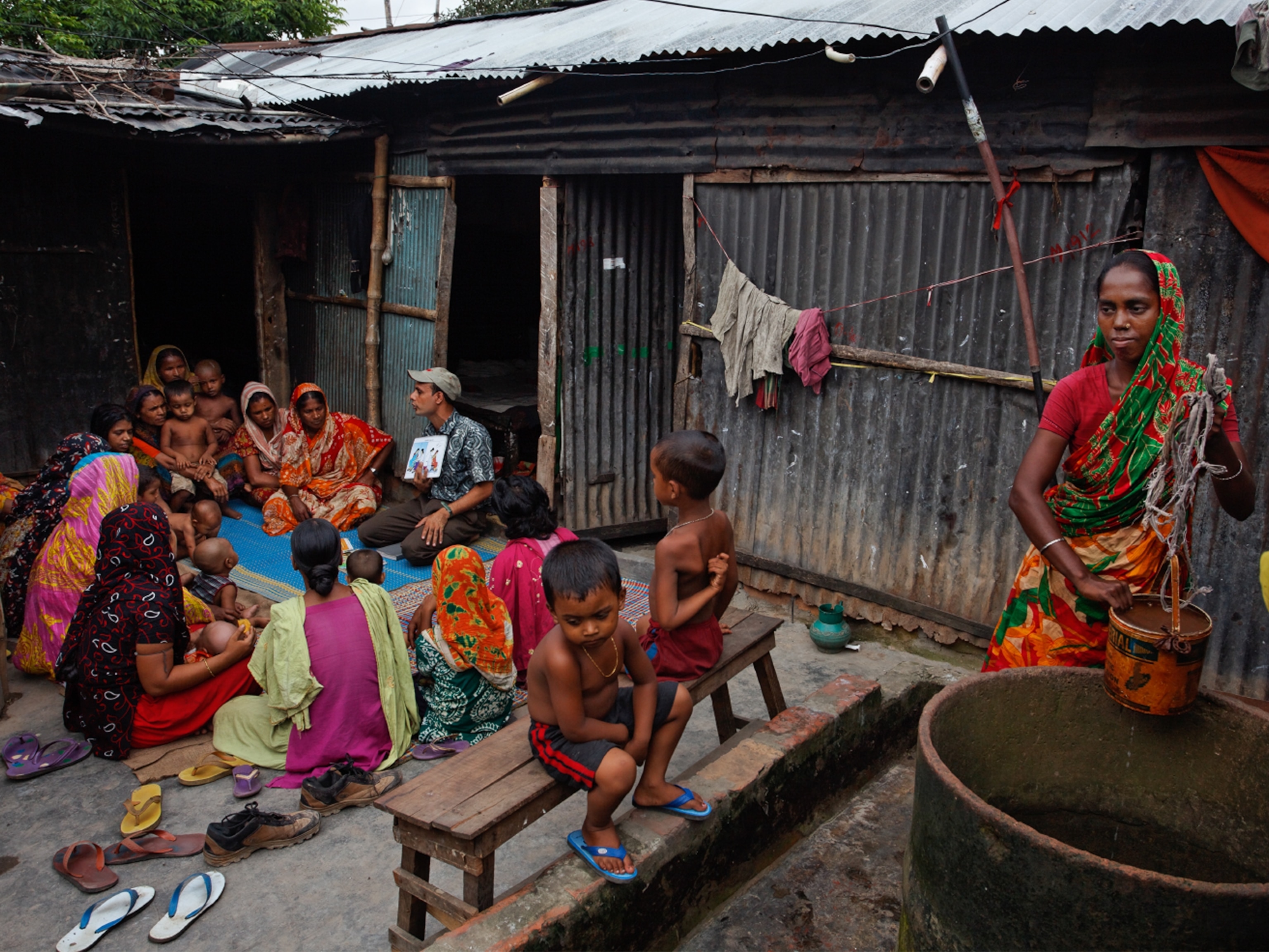 a Ghanian girl reading an english textbook by a small light in the dark.