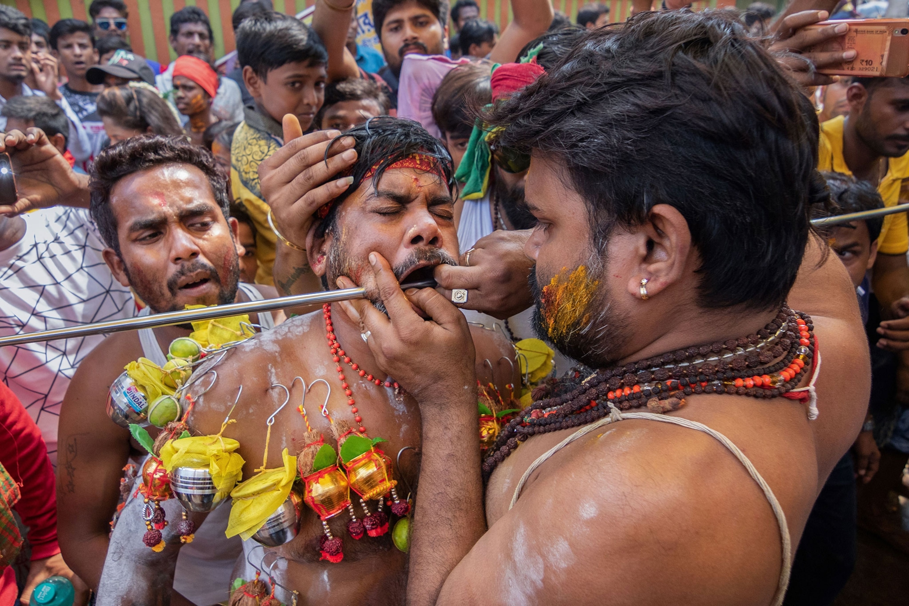 a man's cheeks being pierced during velvel festival