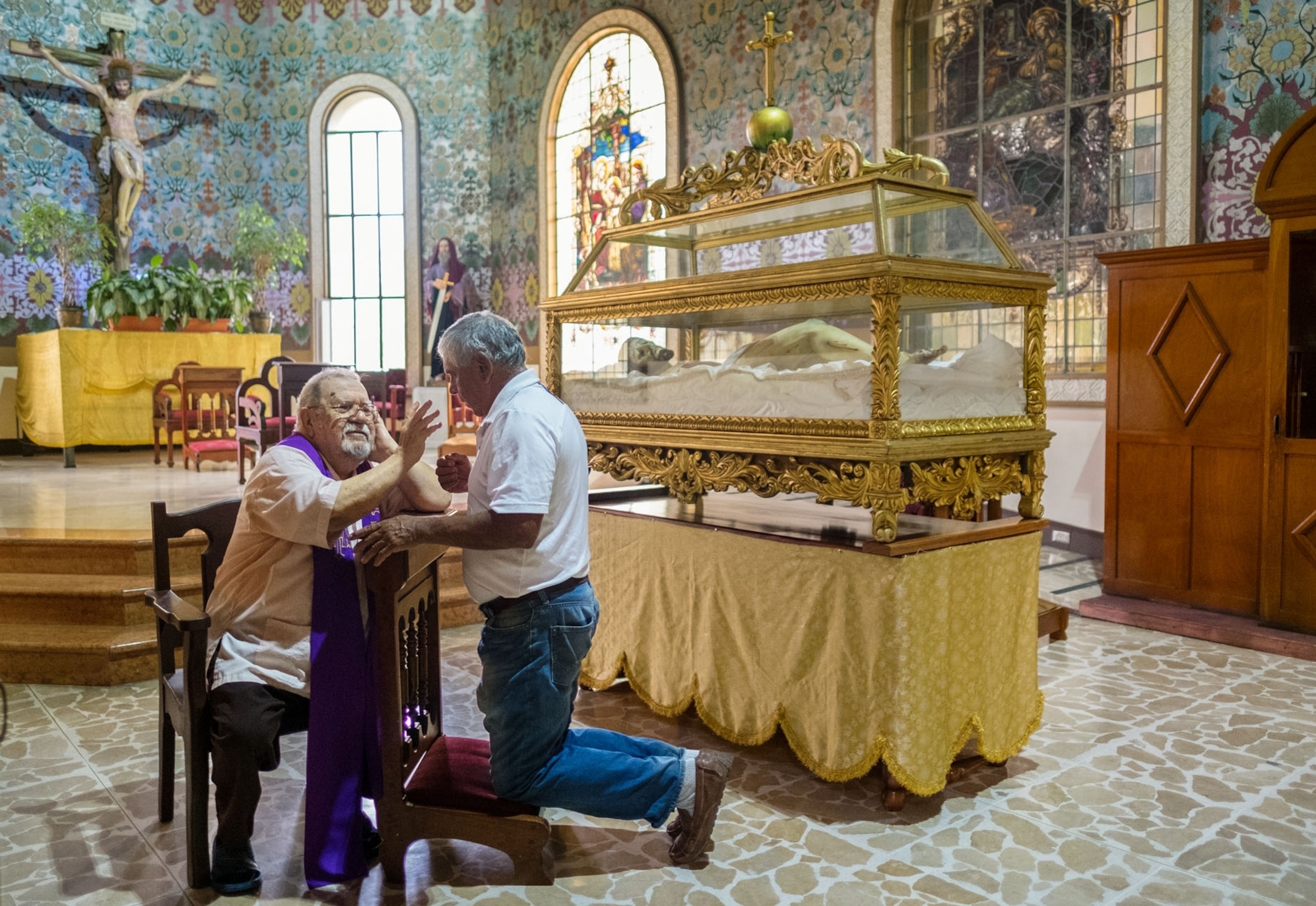 a man confesses his sins to a priest at the Basilica in Cartago, Costa Rica.