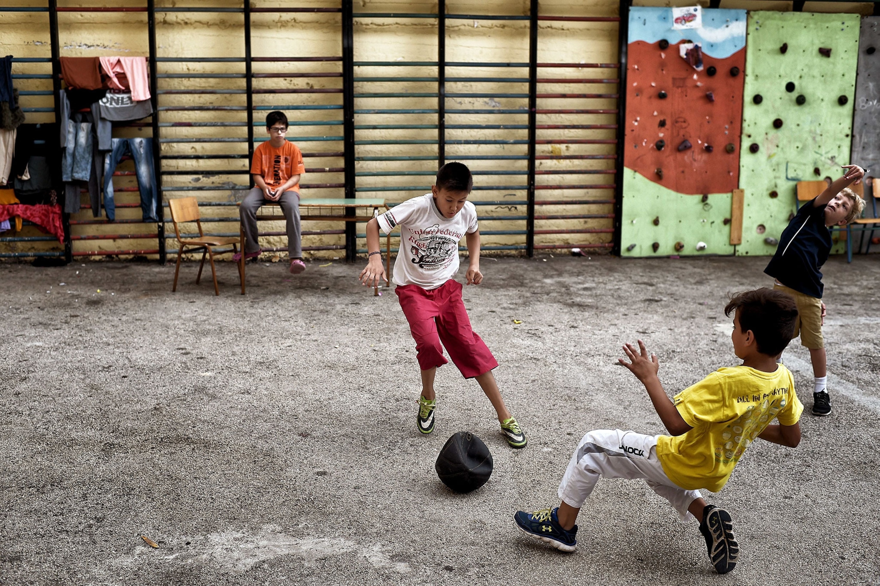 children playing soccer in a courtyard