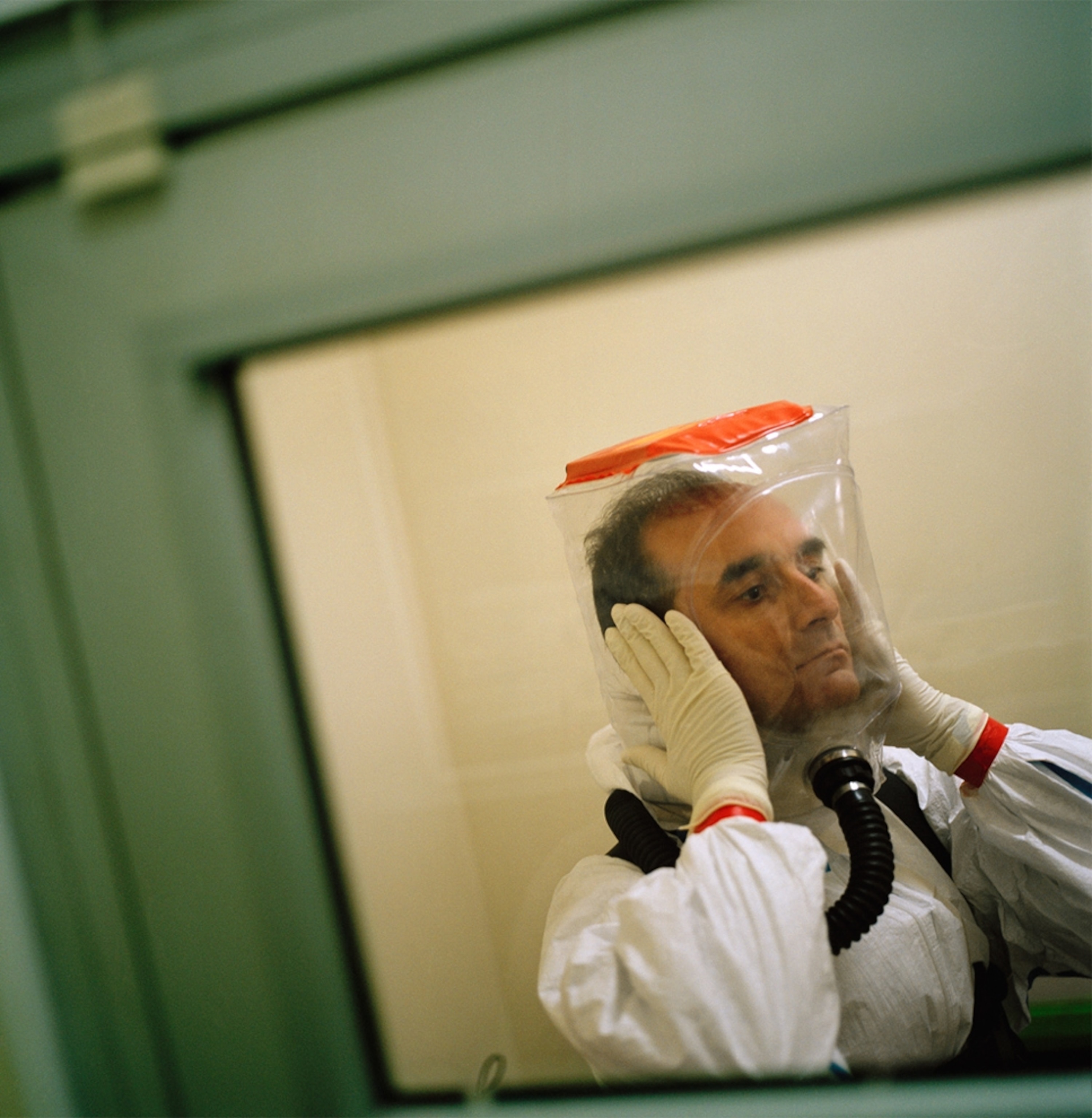 An Ebola researcher decontaminates himself with bleach and water.