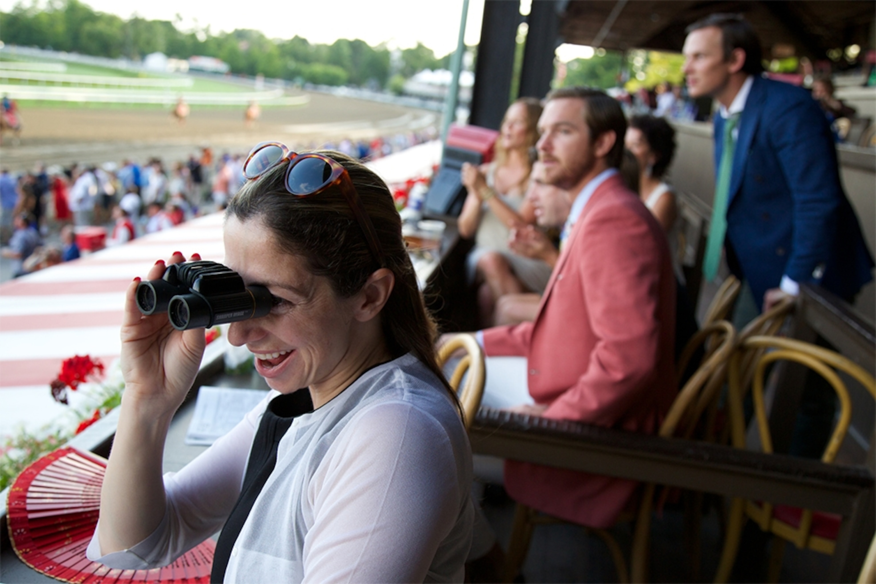 spectator with binoculars at horse race in Saratoga, New York