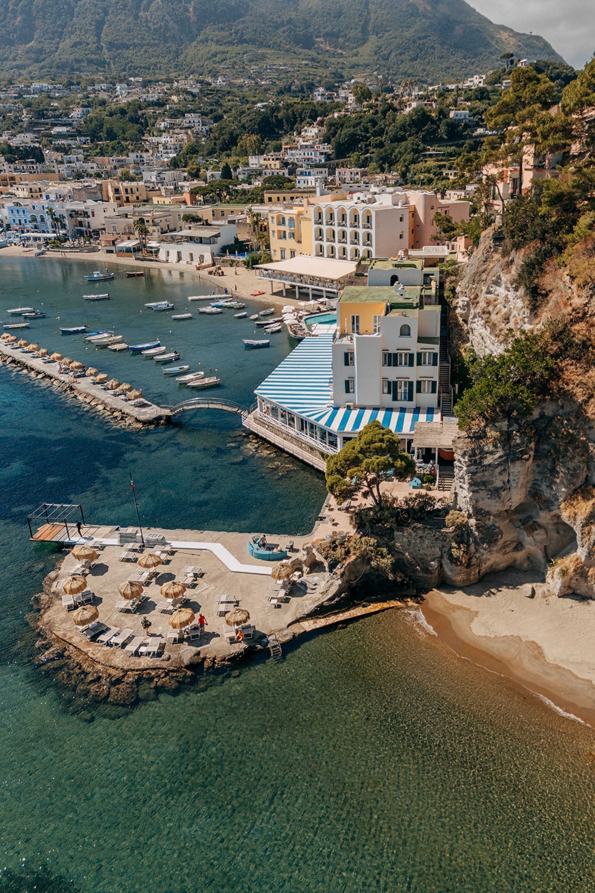 A rugged coast with a beach and promenade in Italy.