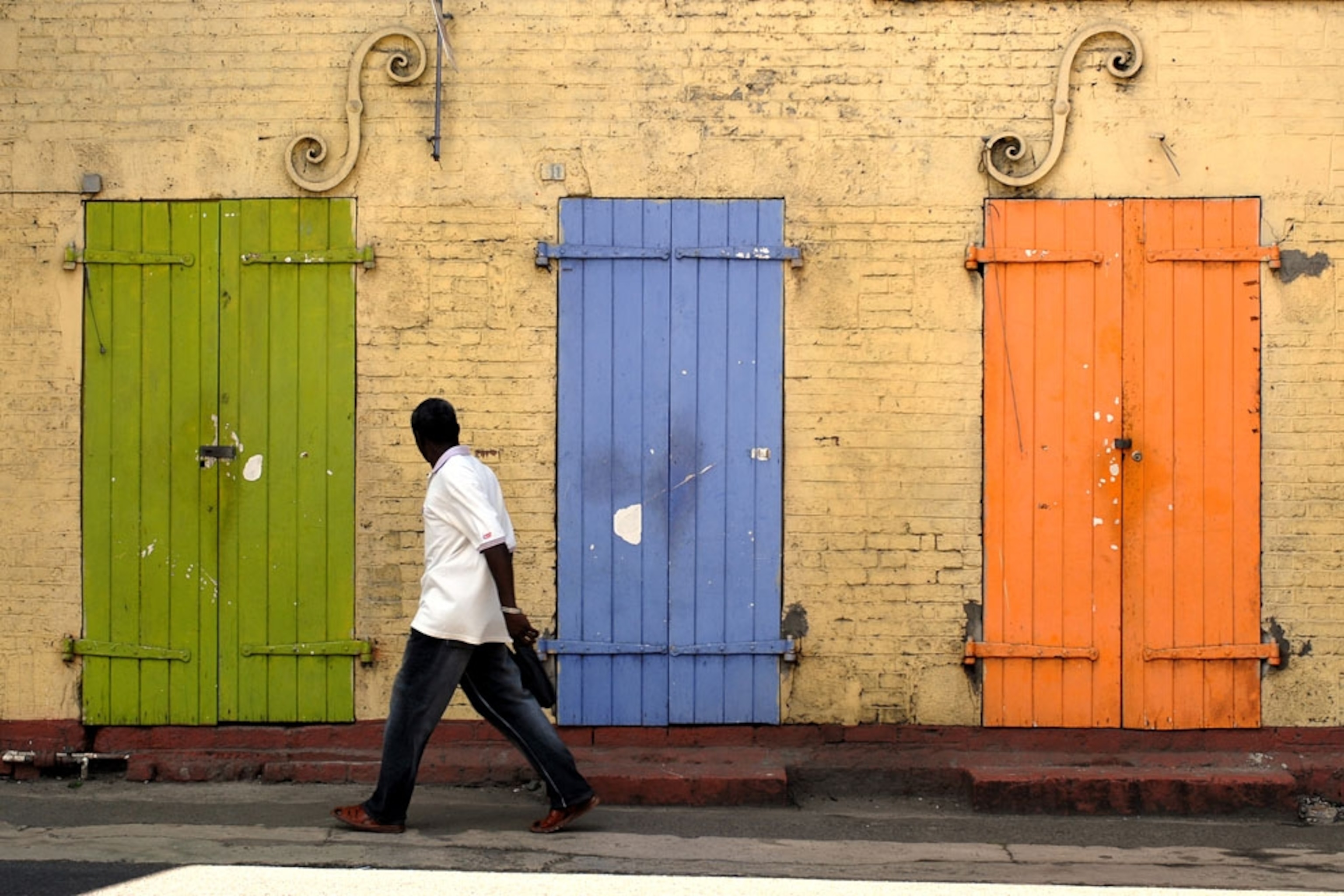 A man walks past colorful doors in the town of Castries on the island of Saint Lucia