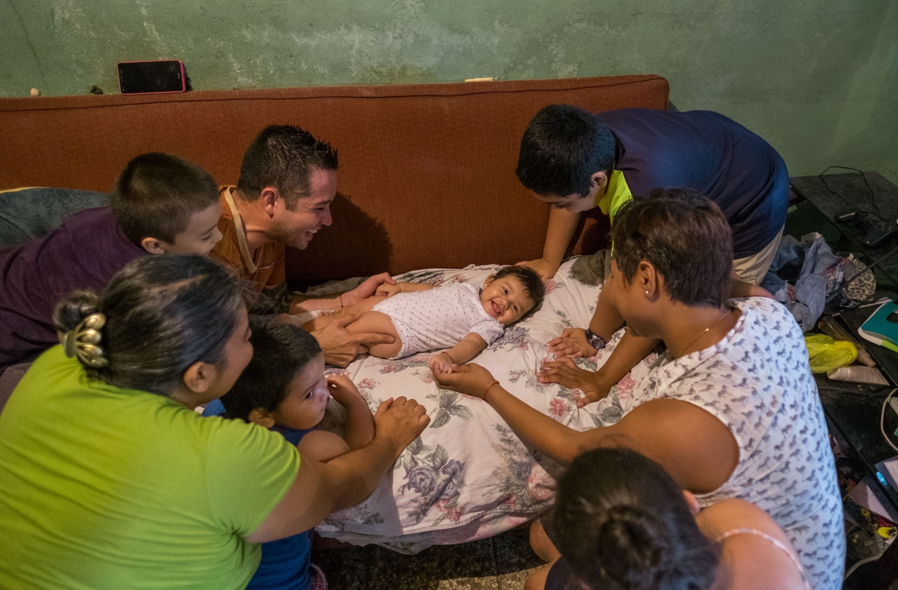 family members gathering around five-month-old baby-girl, Costa Rica.