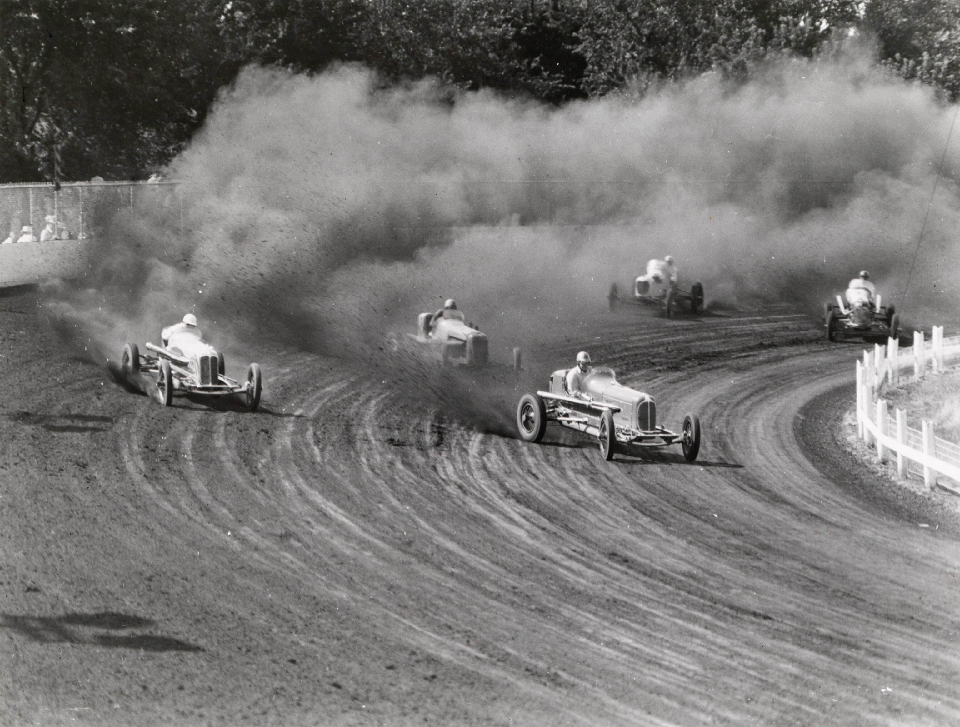 Five autos race on a dirt track at the Iowa State Fair, 1938.
