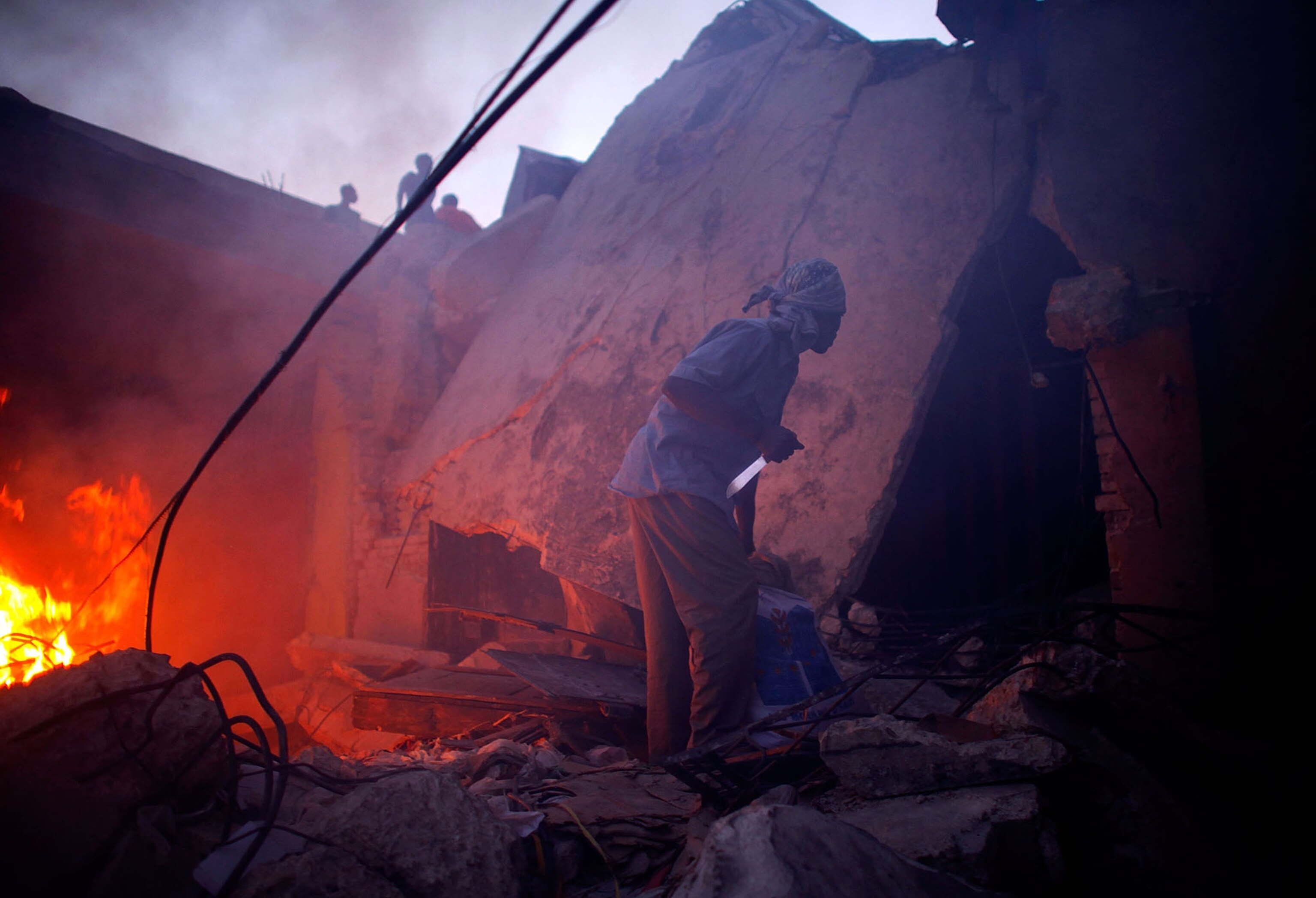 Haitian man holds a knife looking for other looters