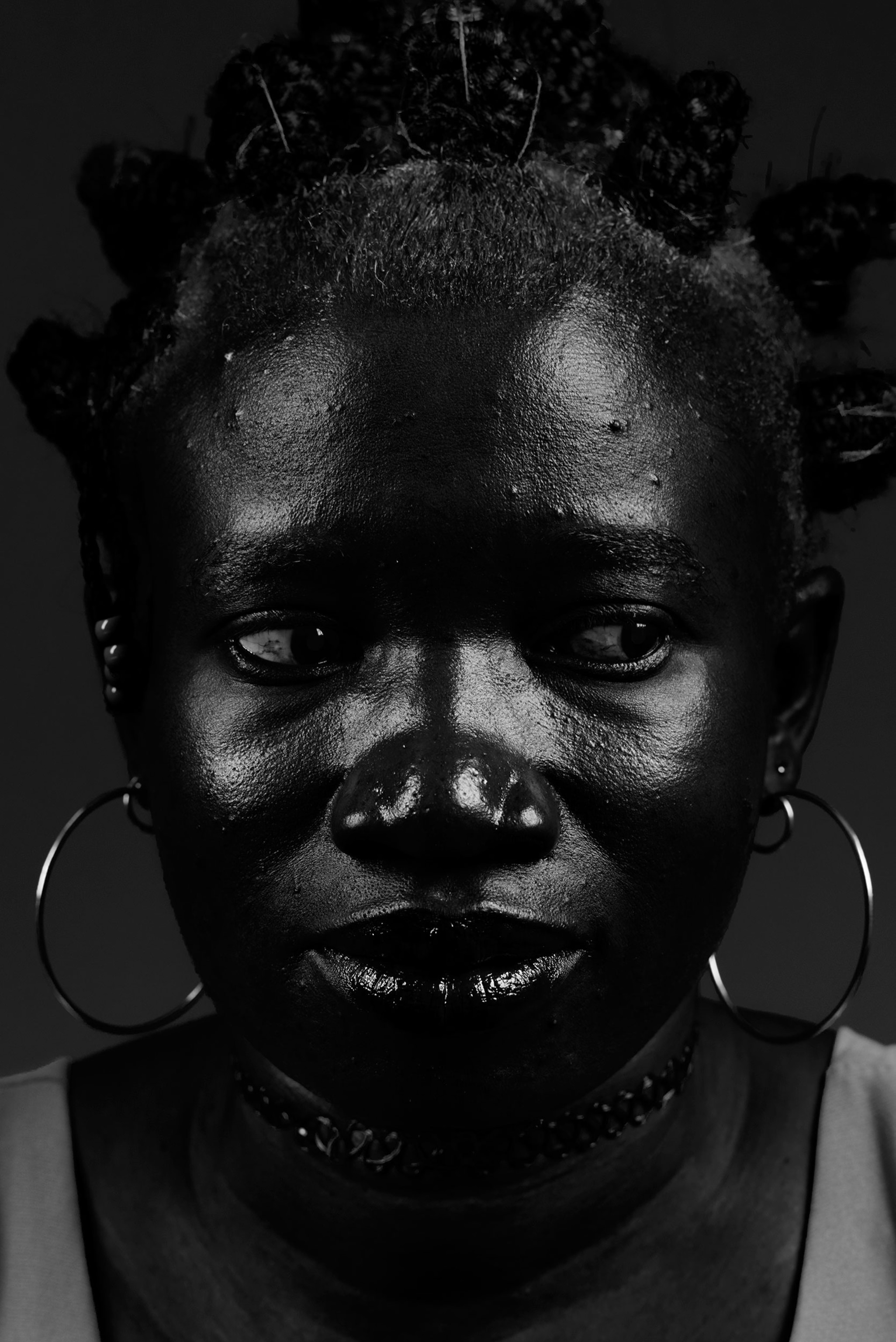 a woman wearing large hoop earrings with her eyes averted