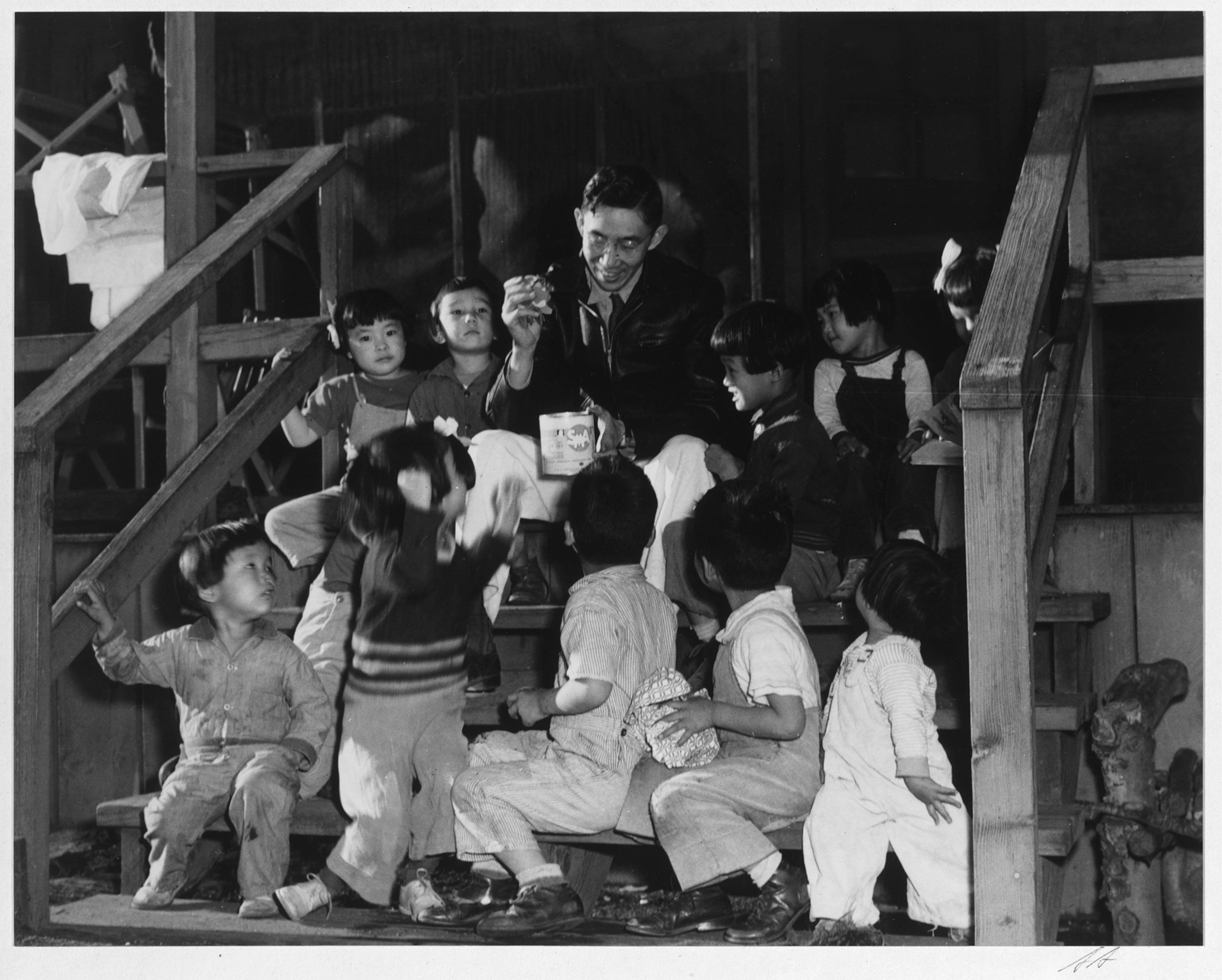 Mr. Matsumoto sits with a group of young children