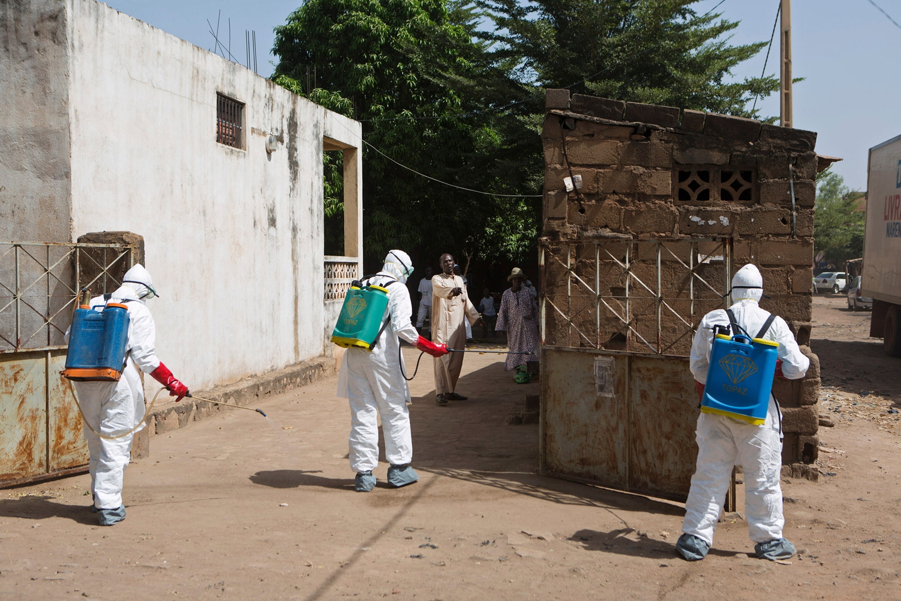 Children watch as health workers spray disinfectants at a mosque in Bamako November 14, 2014.