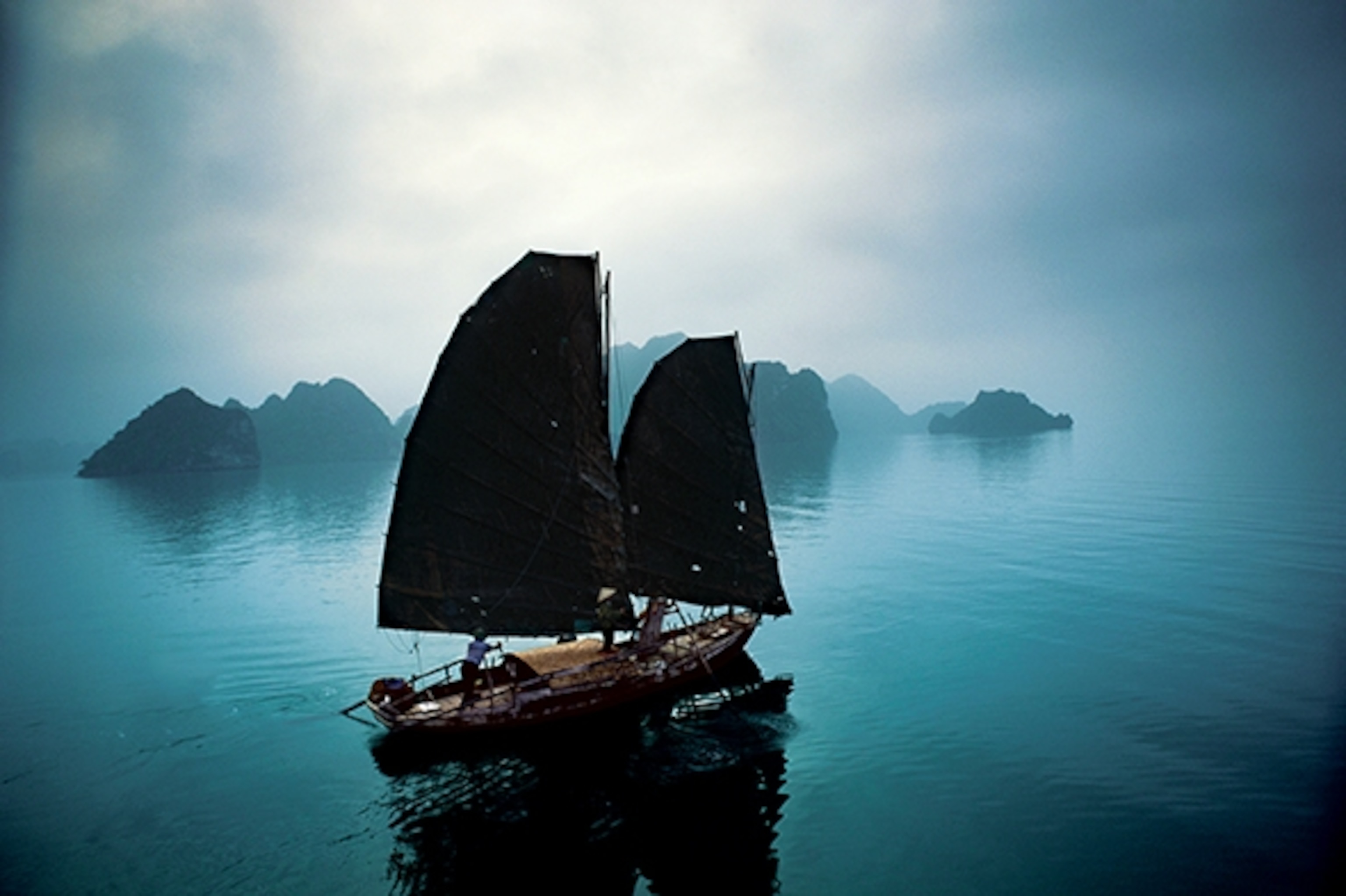 A traditional fishing junk completes a timeless scene on Ha Long Bay, a UNESCO World Heritage site scattered with some 1,600 islands and islets. (Photograph by Catherine Karnow)