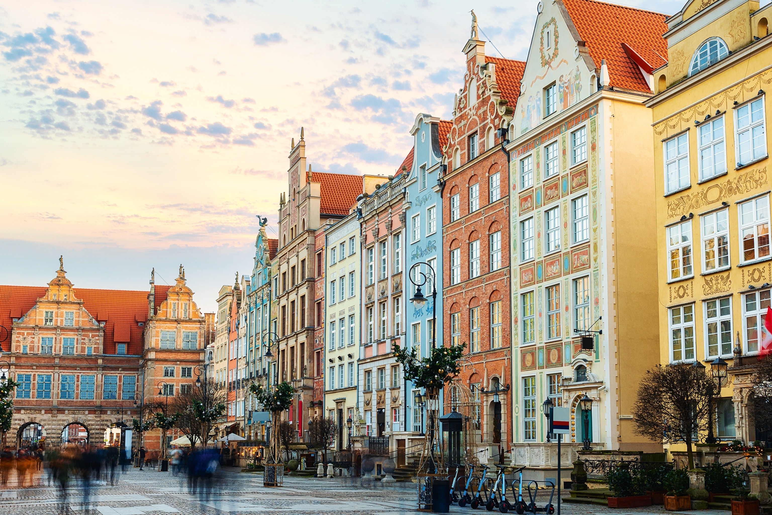 A romantic city square with a fountain and colourful buildings.