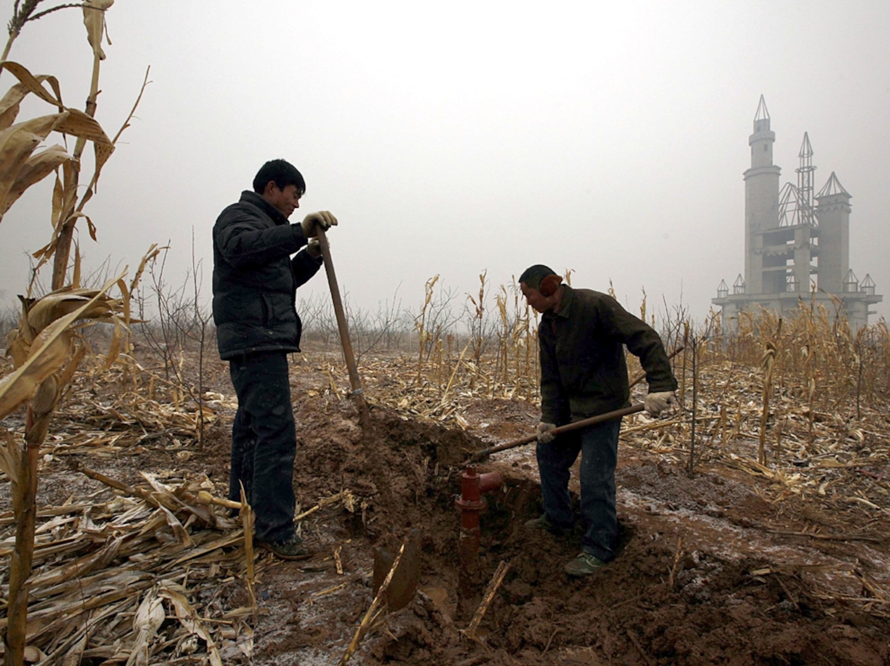 China fake Disneyland picture: farmers dig a well for water, for a gallery on Wonderland, an abandoned project to build an amusement park outside of Beijing, China