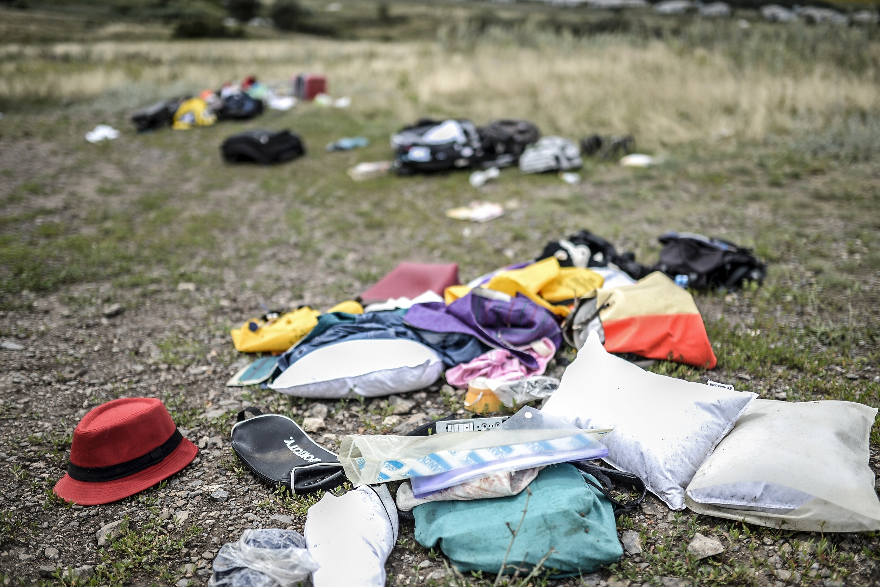 Bodies of victims wrapped in bags wait to be collected by rescuers on the side of the road at the site of the crash of a Malaysia Airlines plane carrying 298 people from Amsterdam to Kuala Lumpur in Grabove, in rebel-held east Ukraine, on July 19, 2014.