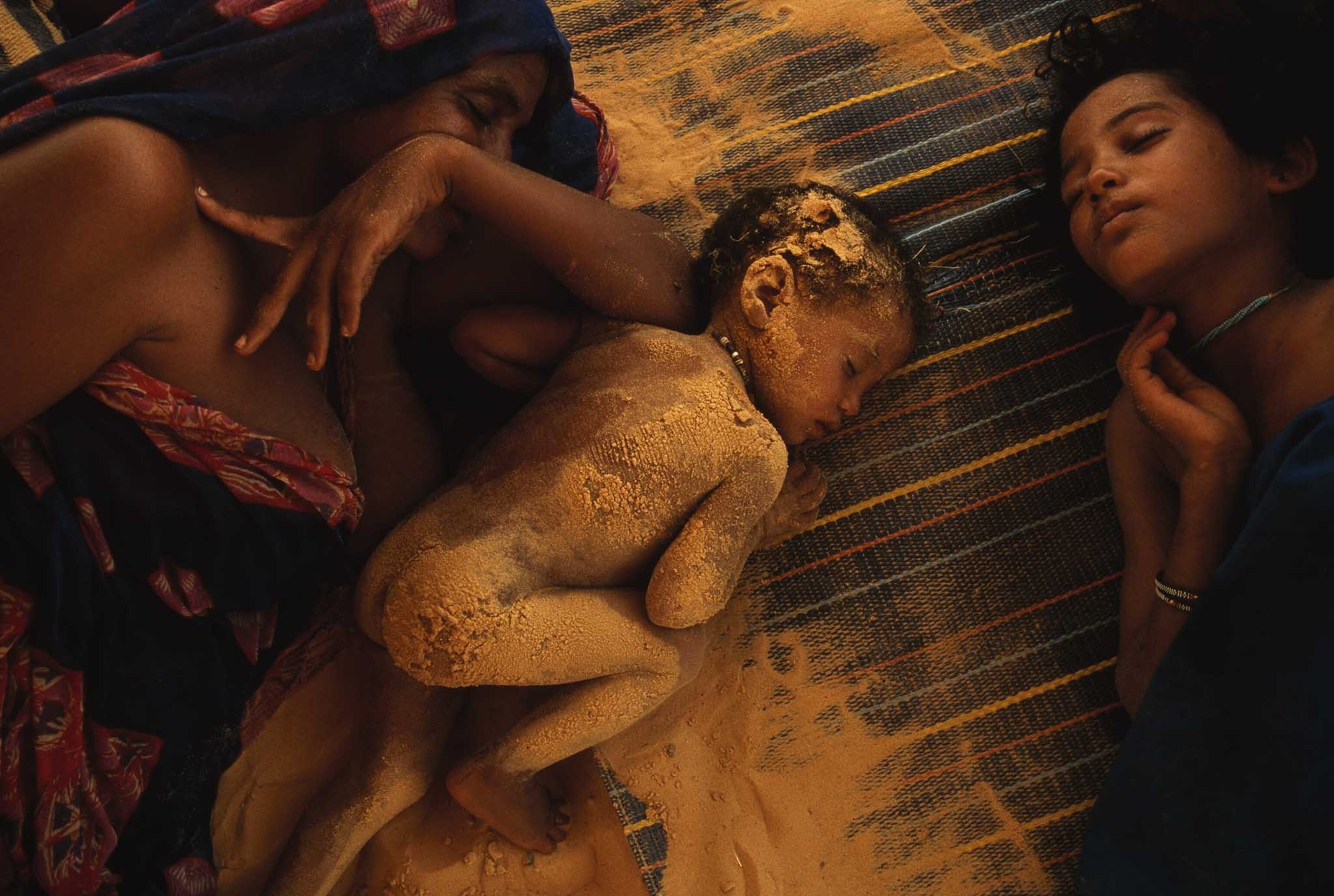 a Tuareg family doze through midday heat near Timbuktu in drought-stricken Mali