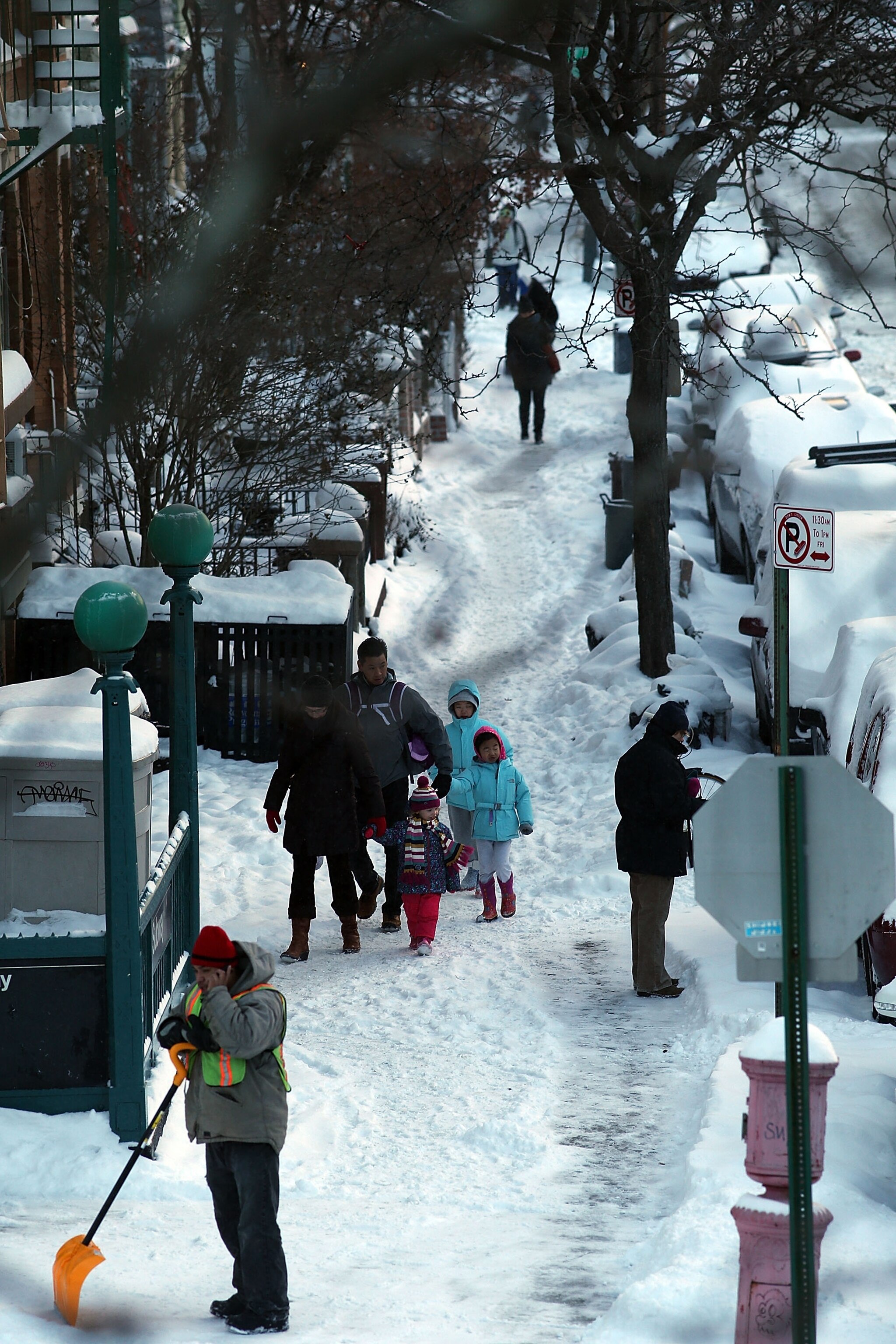 A woman walks outside of an office building as snow falls, Tuesday, Jan. 21, 2014, in Baltimore. Thousands of flights were canceled, students got an extra day off from school or were being sent home early, and the federal government closed its offices in the Washington area Tuesday as another winter storm bore down on the Mid-Atlantic and Northeast.