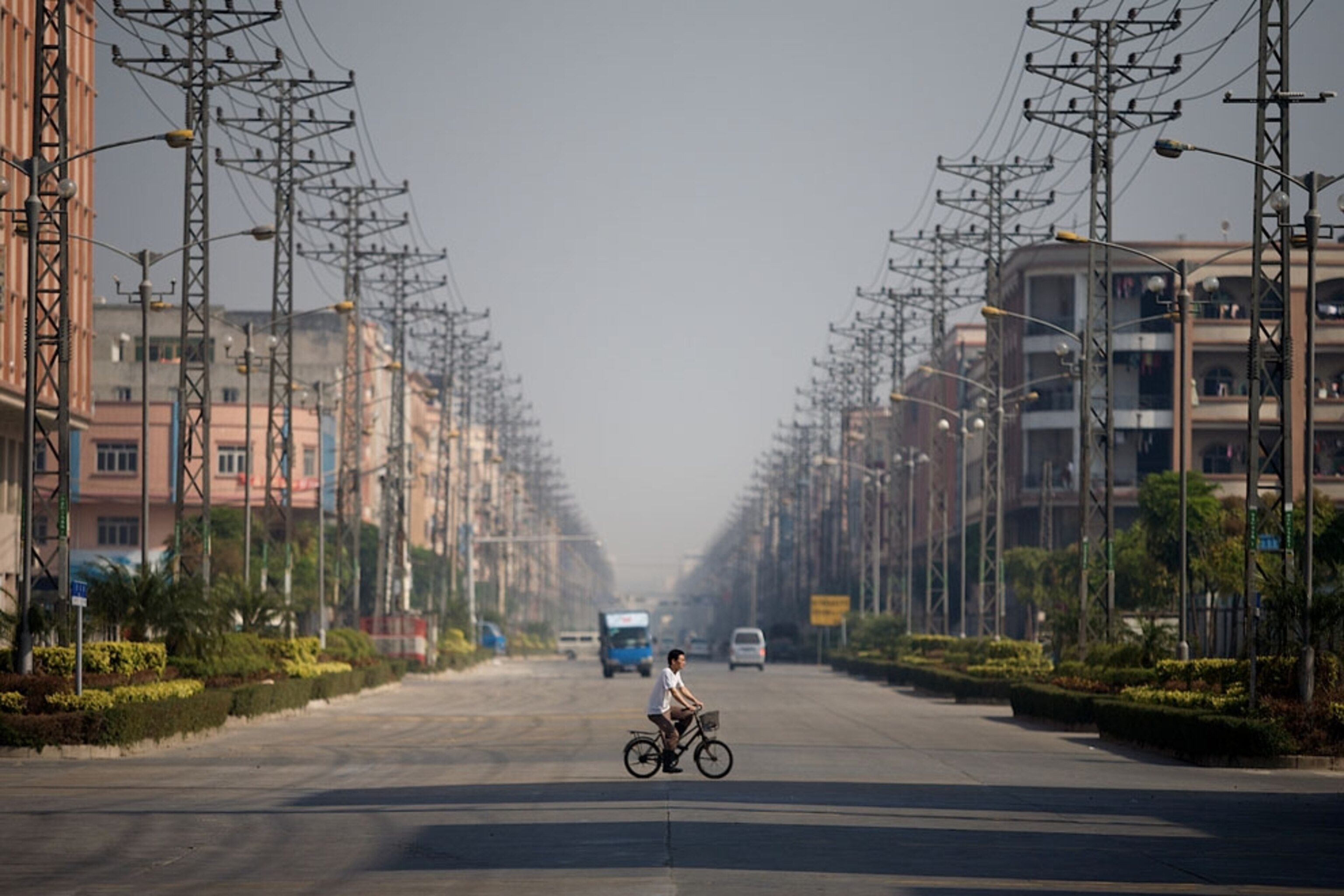 A man walking his bike in the street in Pearl River Delta, China