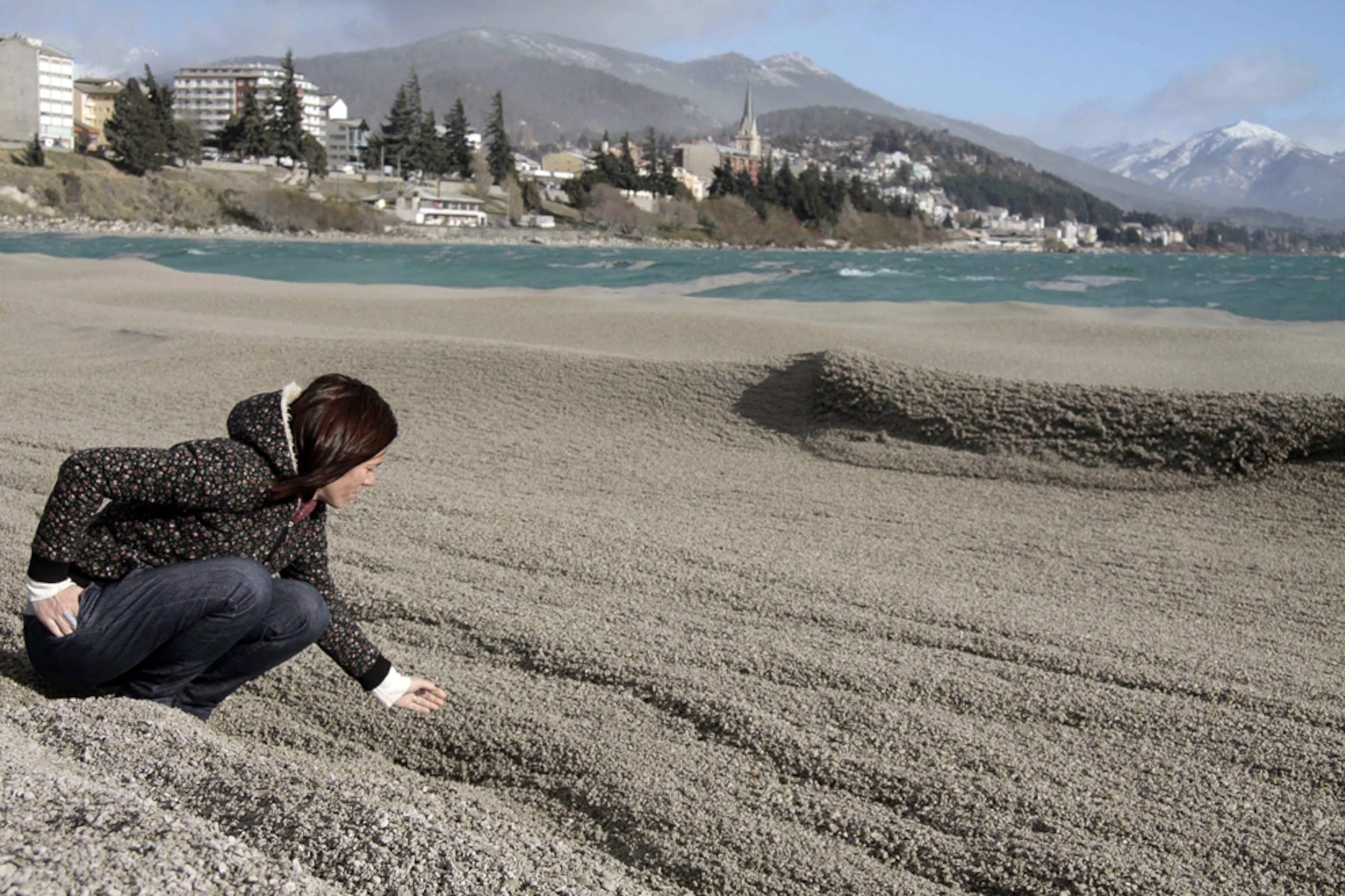 Volcano picture: woman touching ash in lake from the Chile volcano