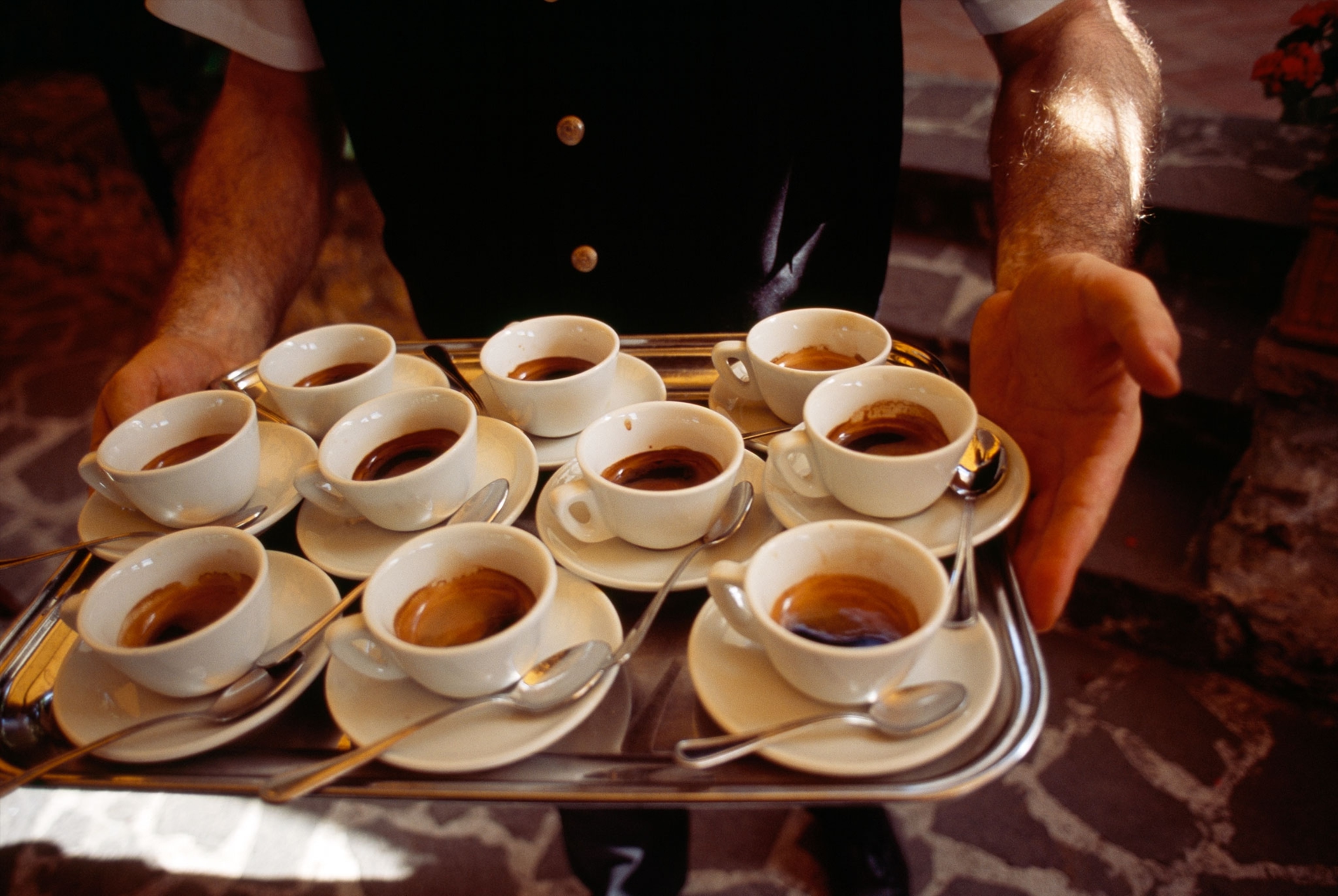 a waiter carrying a tray of espresso in Tuscany, Italy