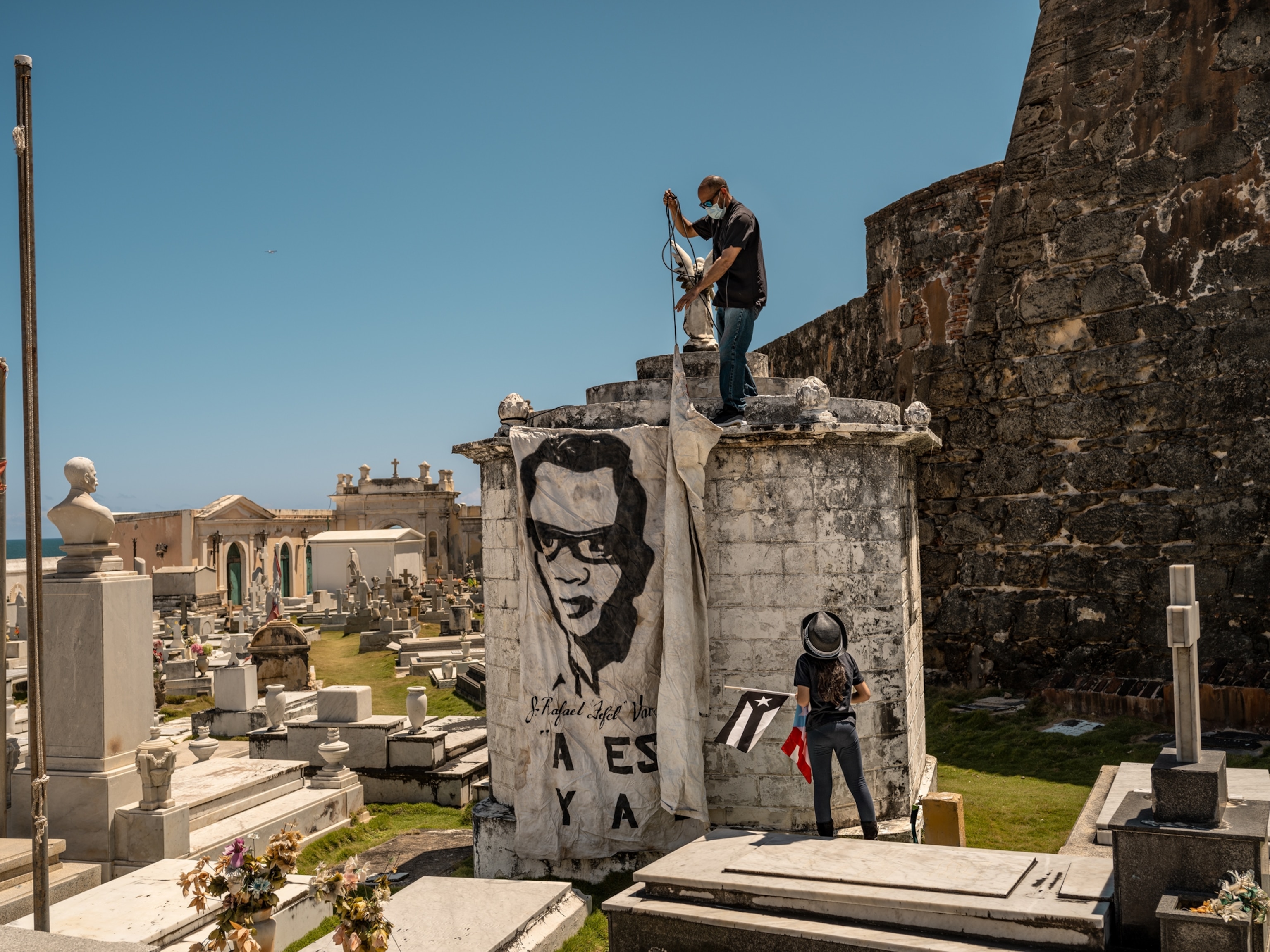Man removing a banner from the memorial at the cemetary.